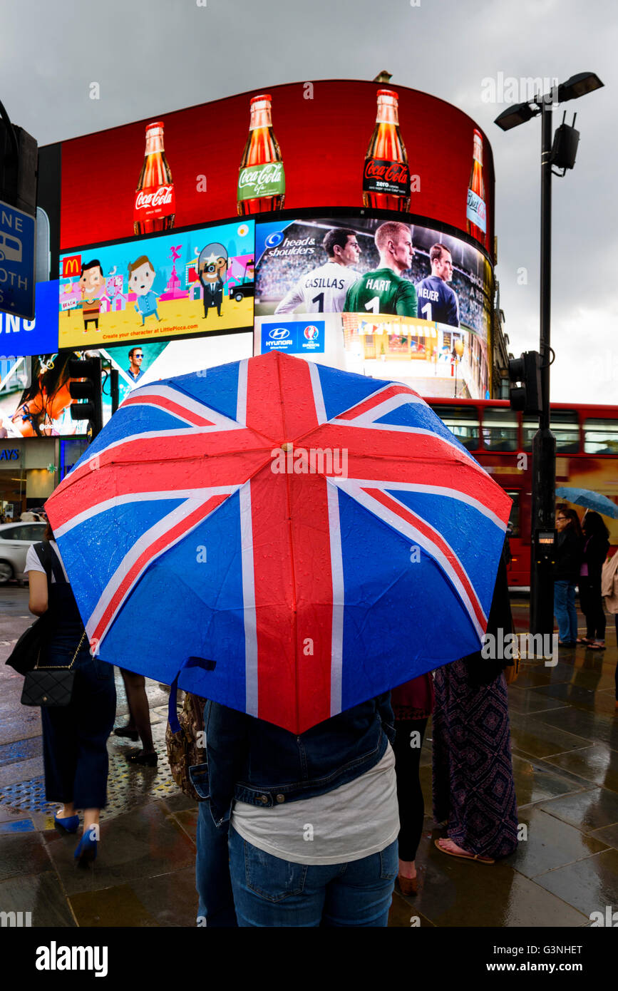 Tourists with Union Jack umbrella at Piccadilly circus on a rainy day in London, UK. Stock Photo
