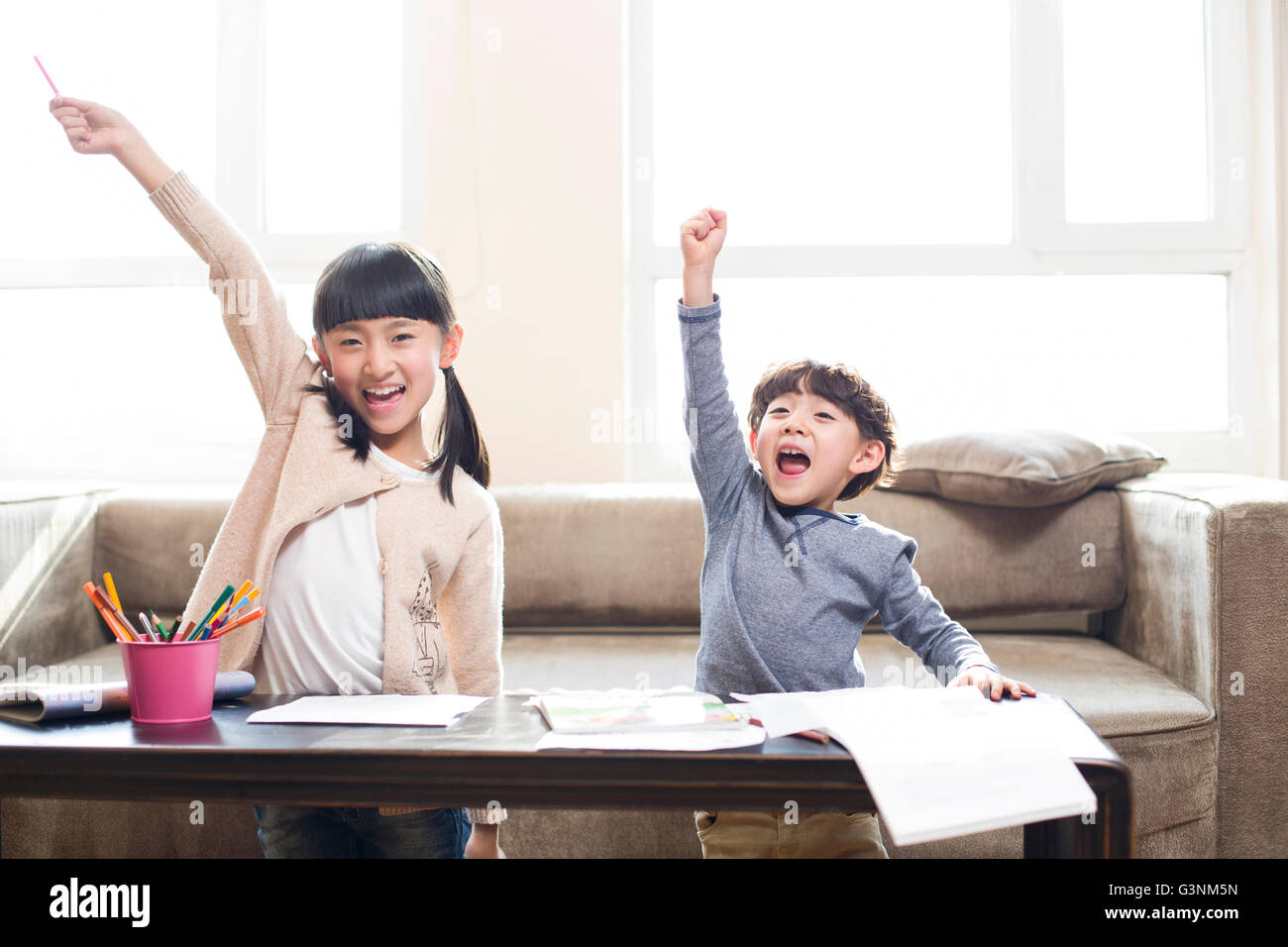 Happy siblings studying together at home Stock Photo - Alamy