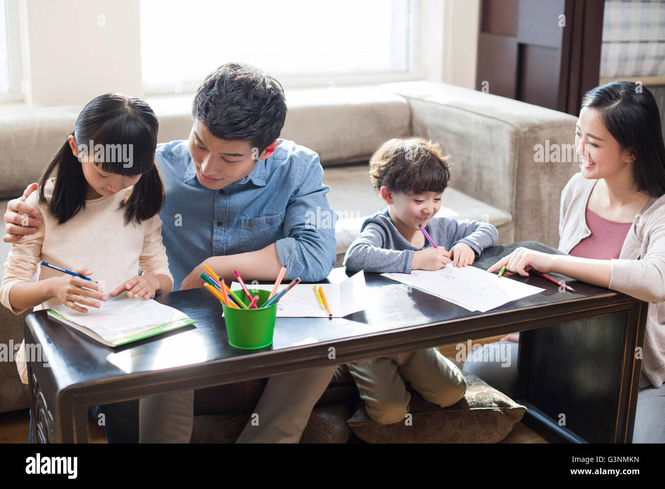 Young parents helping their children with homework Stock Photo - Alamy