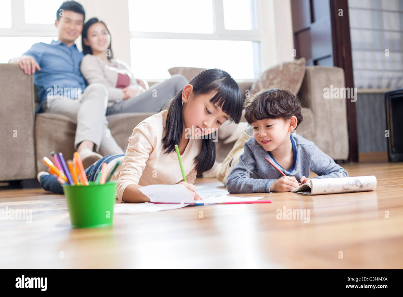 Happy siblings studying together at home Stock Photo - Alamy