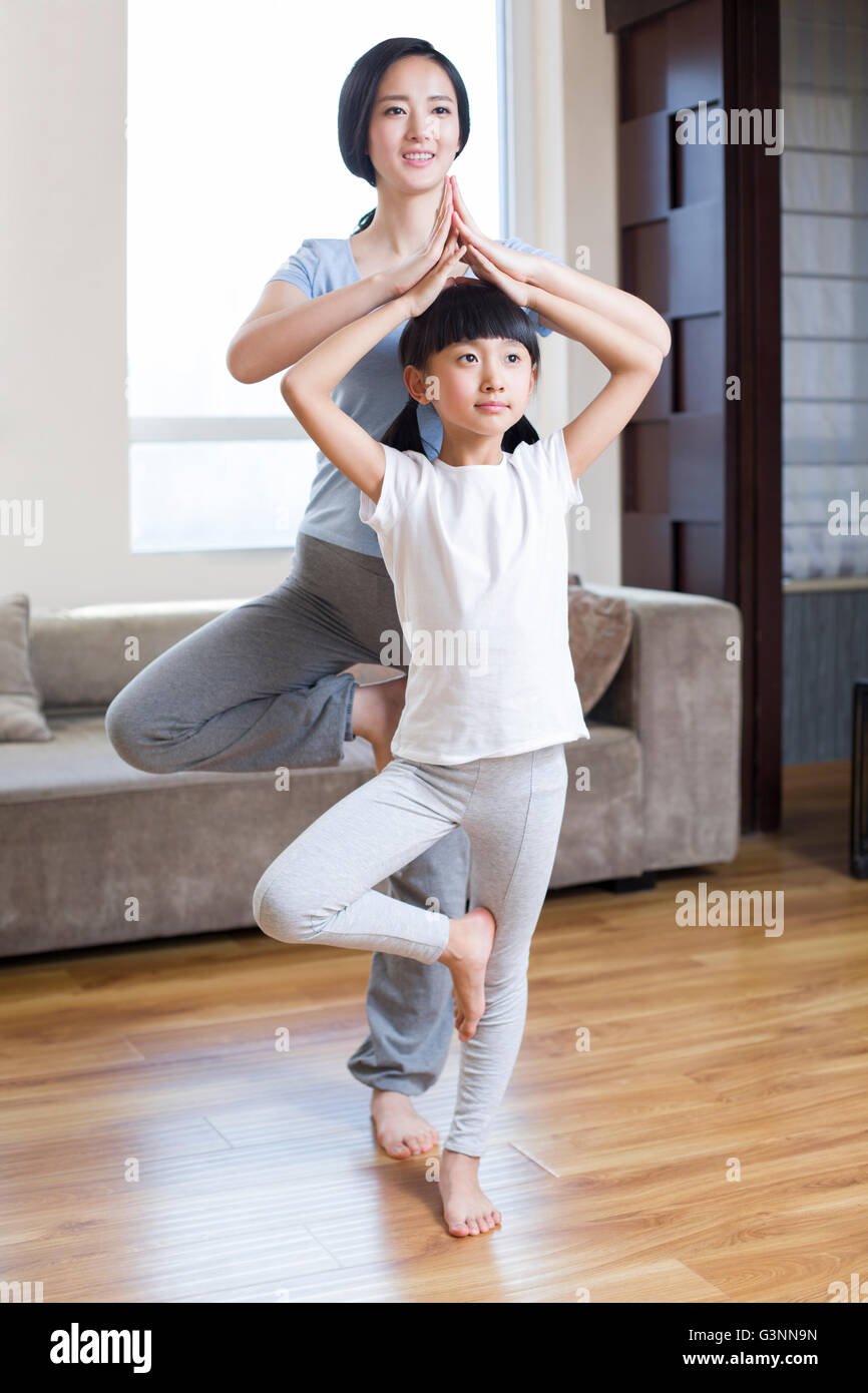 Young mother and daughter doing yoga at home Stock Photo - Alamy