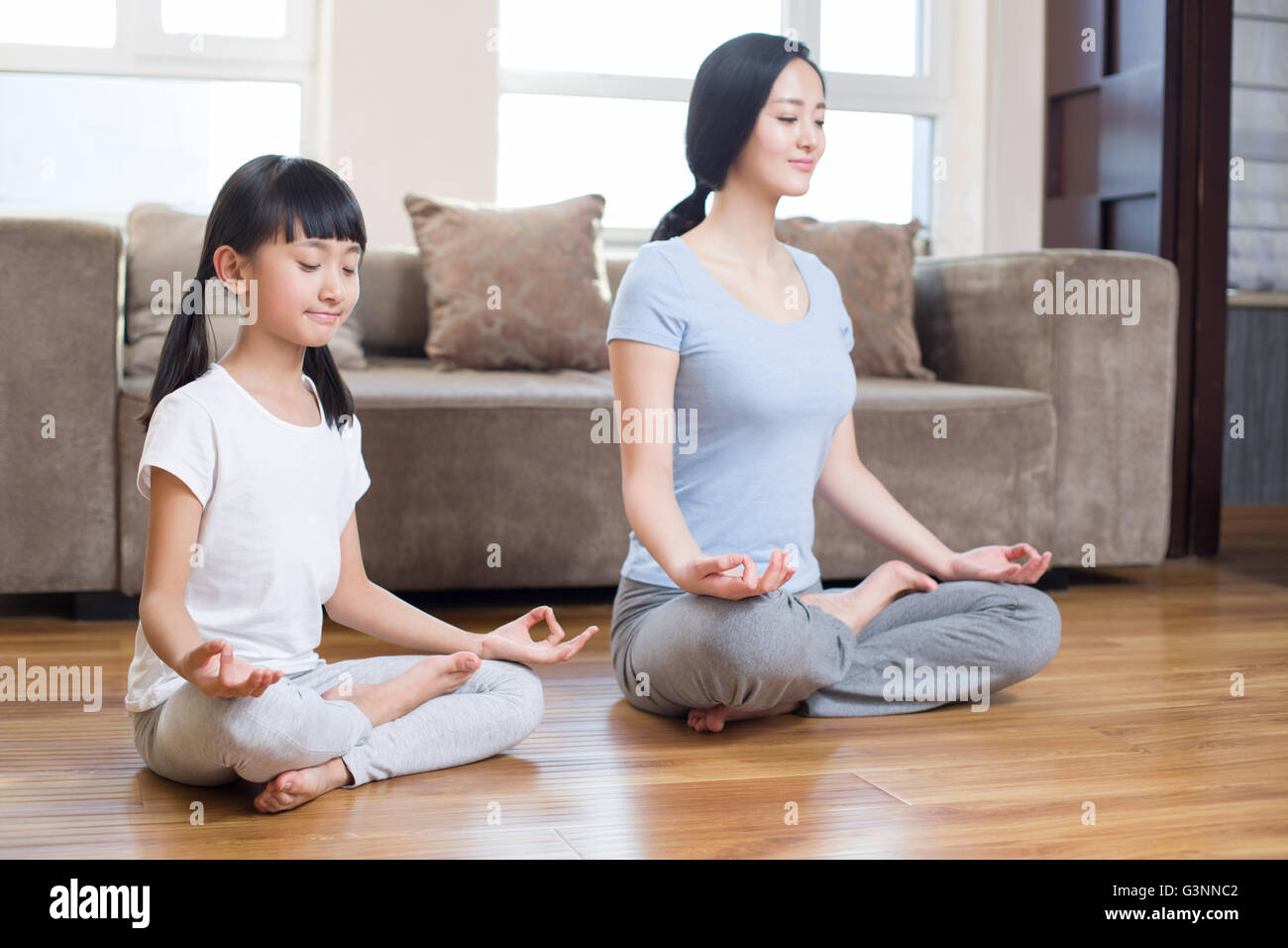 Young mother and daughter doing yoga at home Stock Photo - Alamy