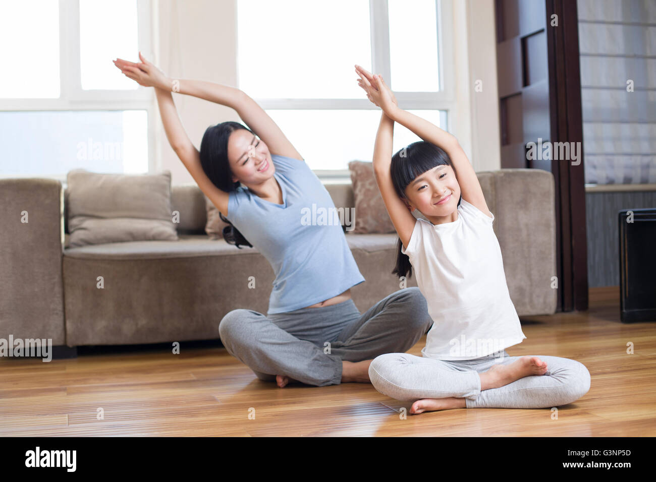 Young mother and daughter doing yoga at home Stock Photo - Alamy