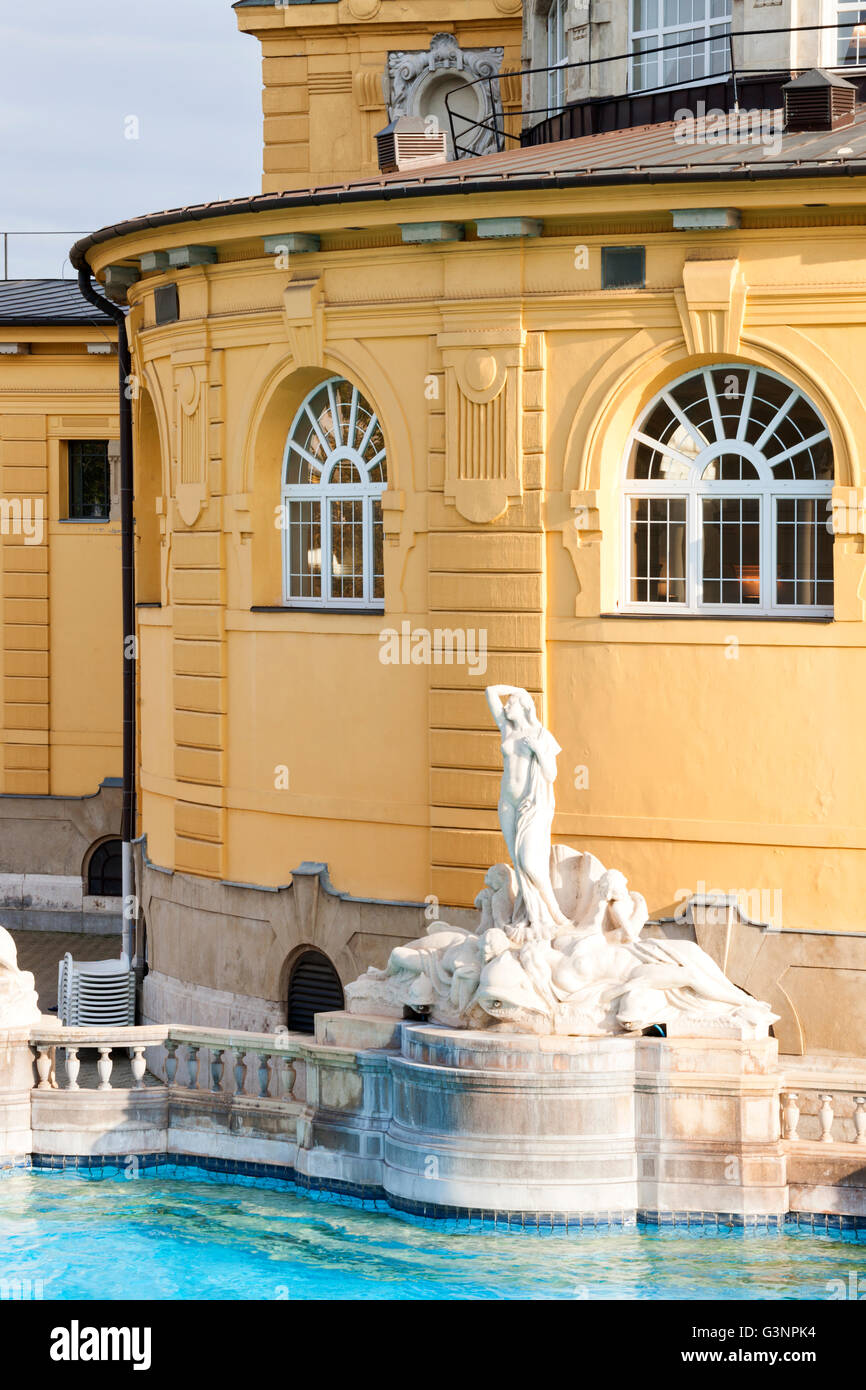 Historic Szechenyi Thermal Baths with the distinctive yellow buildings and marble sculptures along the pool of mineral waters Stock Photo
