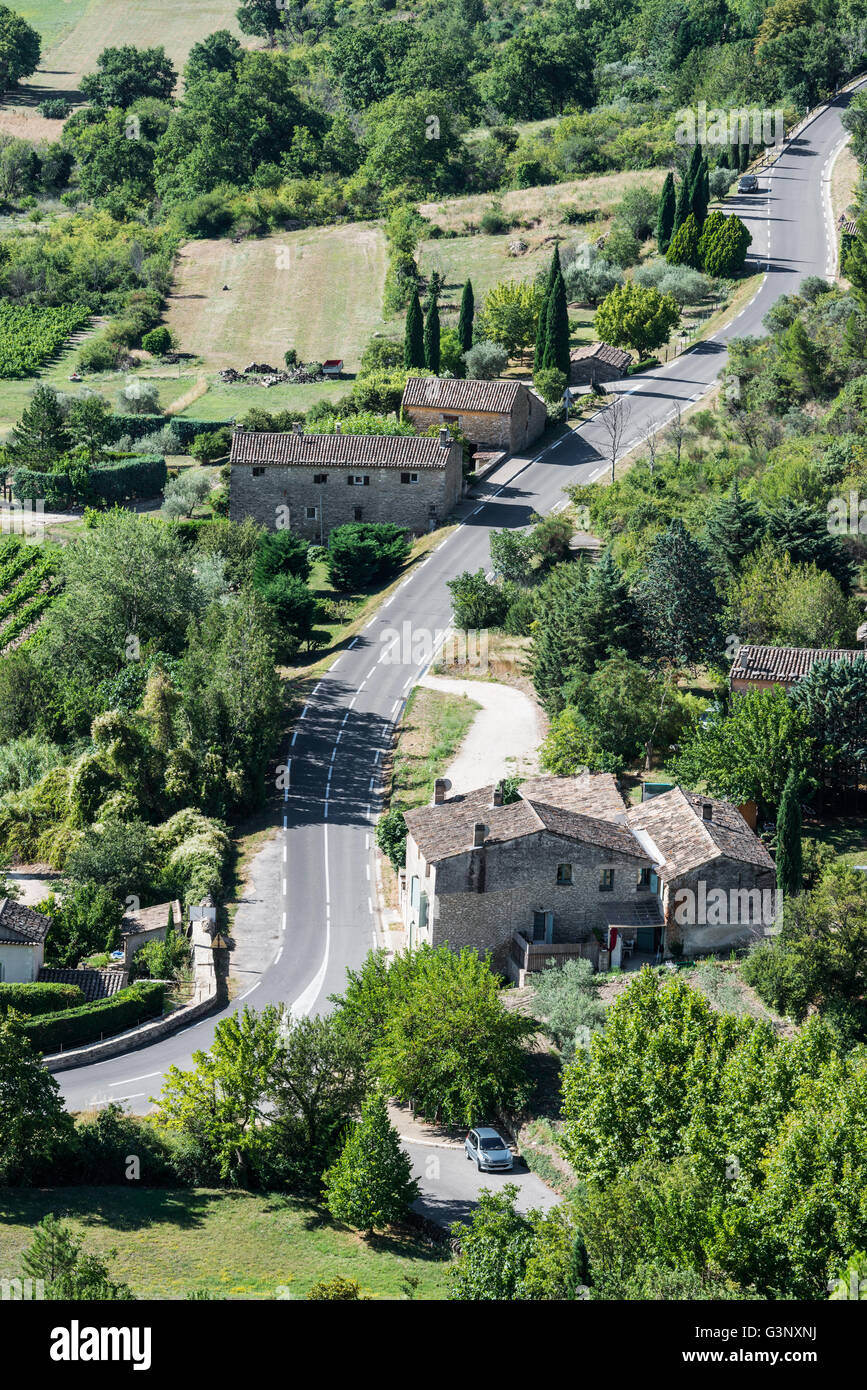 Modern twisted asphalt road across a small green village of Provence Stock Photo