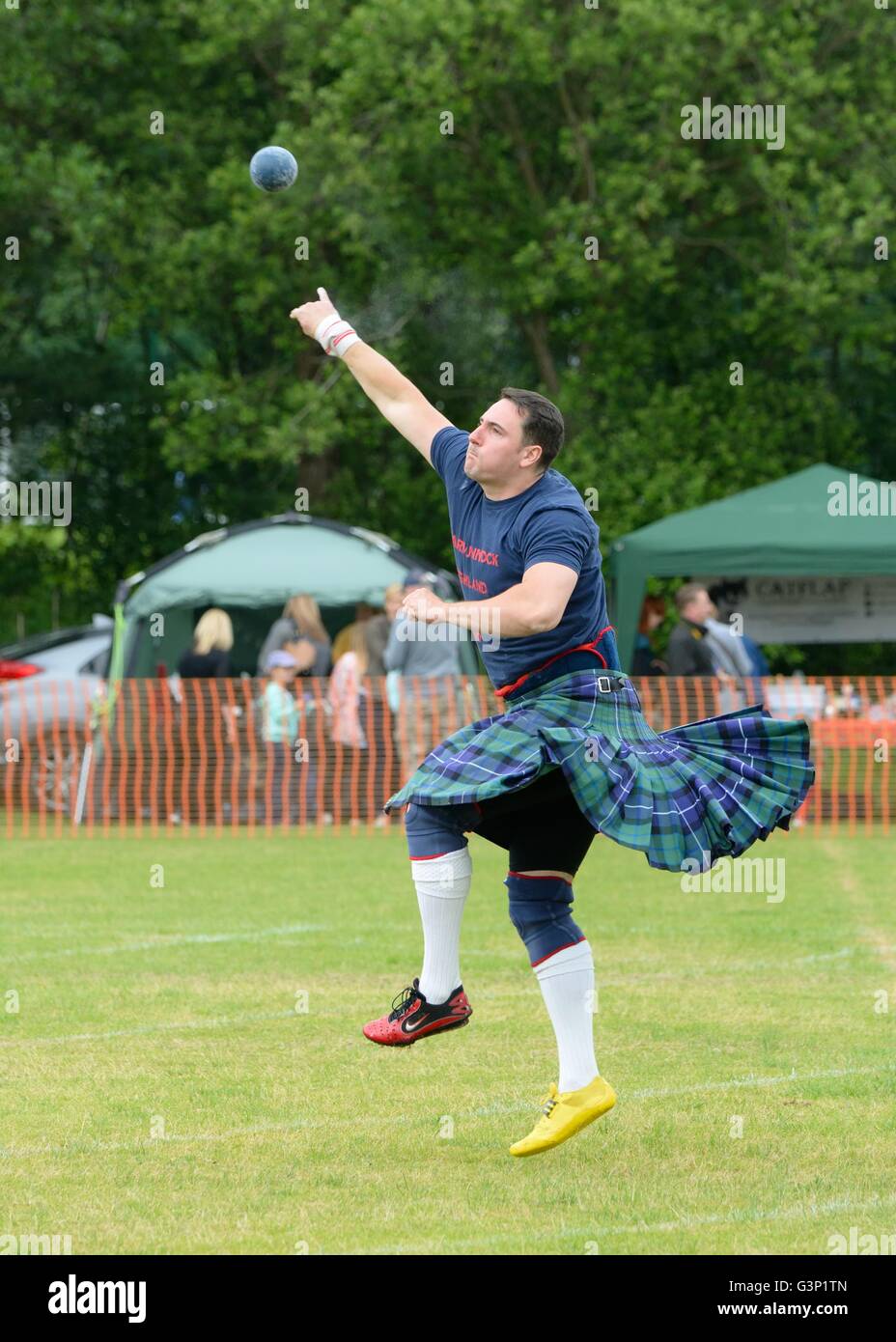 Man in kilt shot putting at Highland Games, Scotland, UK Stock Photo