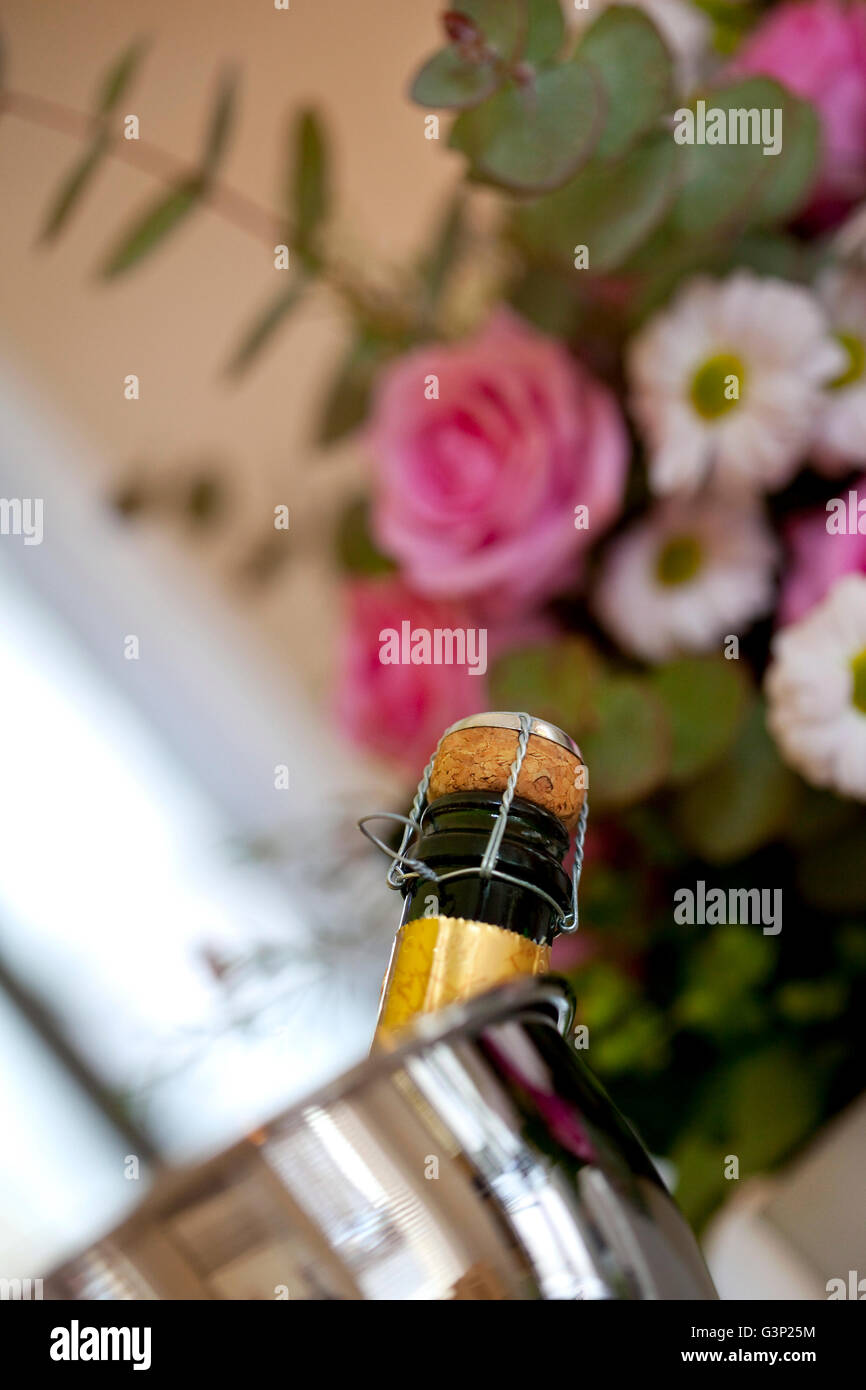 Bottle of champagne in a bucket and bunch of flowers in a wine bar Stock Photo