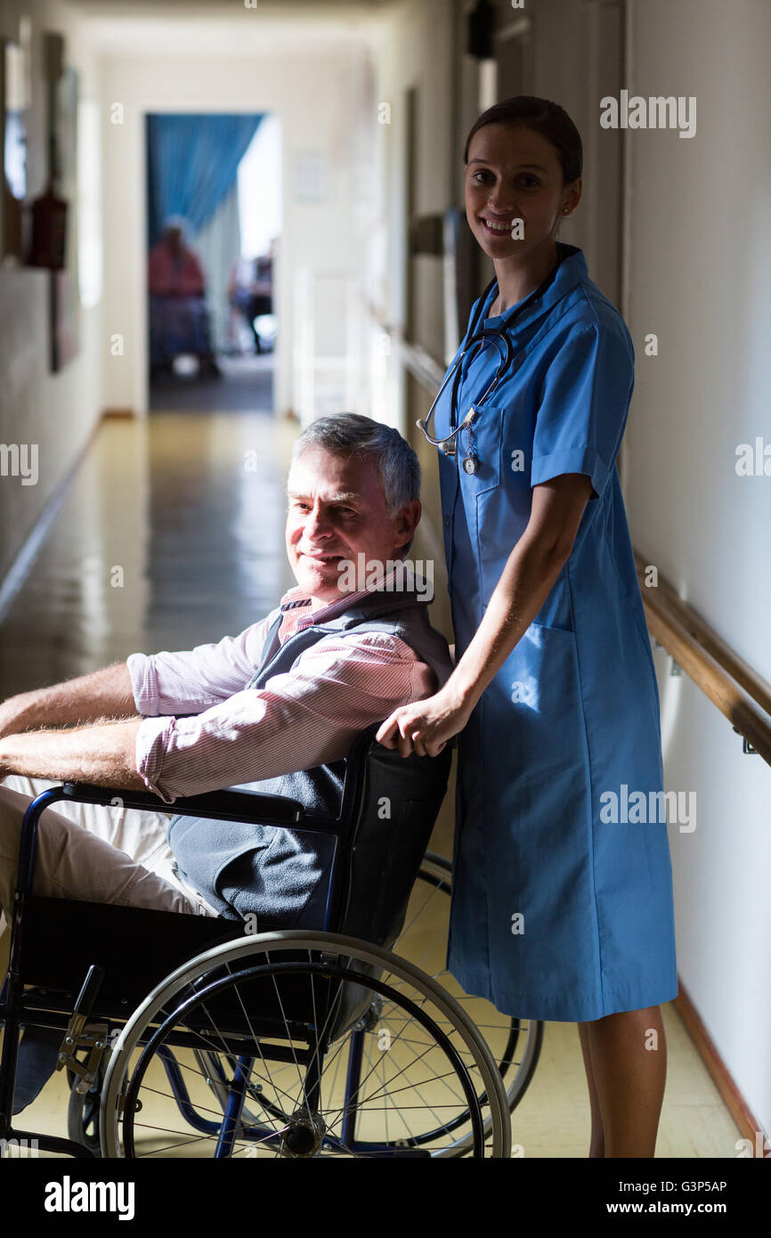 Portrait of patient in a wheelchair pushing by a nurse Stock Photo - Alamy