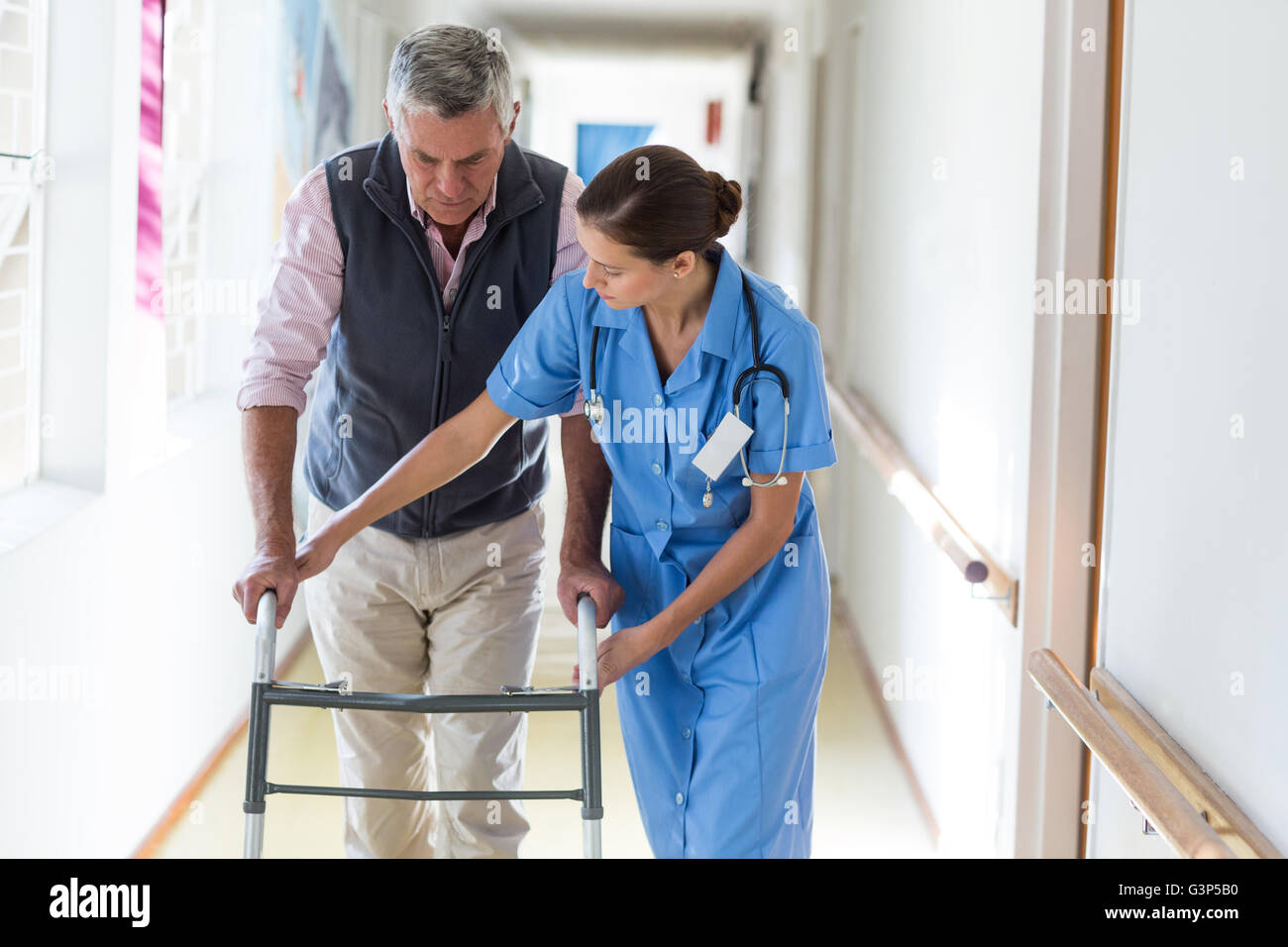 Nurse helping senior patient to walk with walking frame Stock Photo Alamy