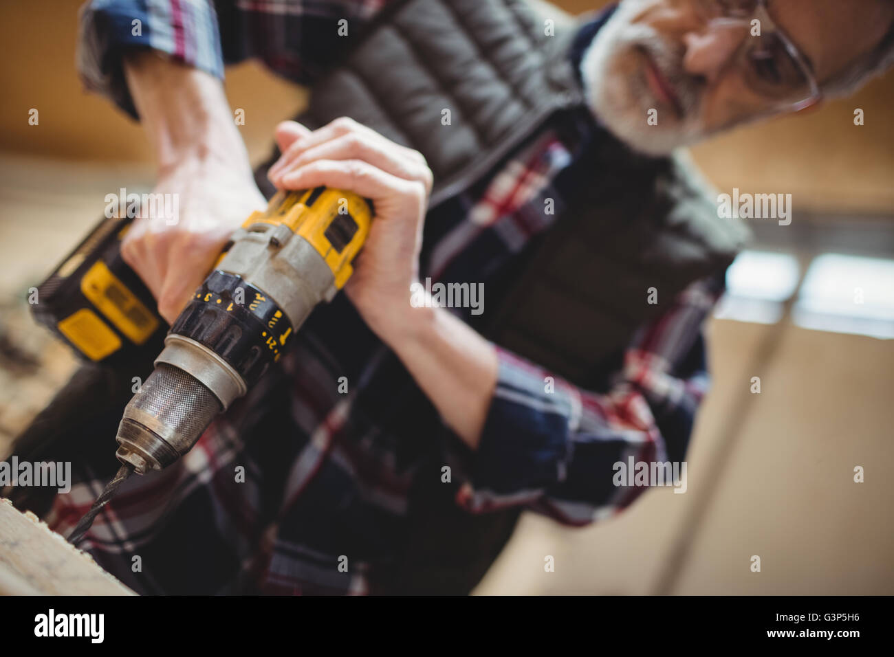 Carpenter drilling a plank of wood Stock Photo