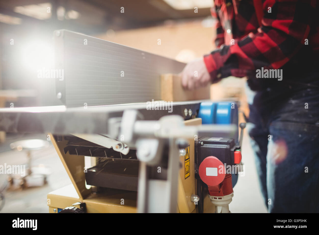 Carpenter sawing a plank of wood Stock Photo