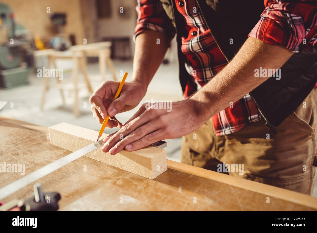 Carpenter writing a mark on a wood piece Stock Photo