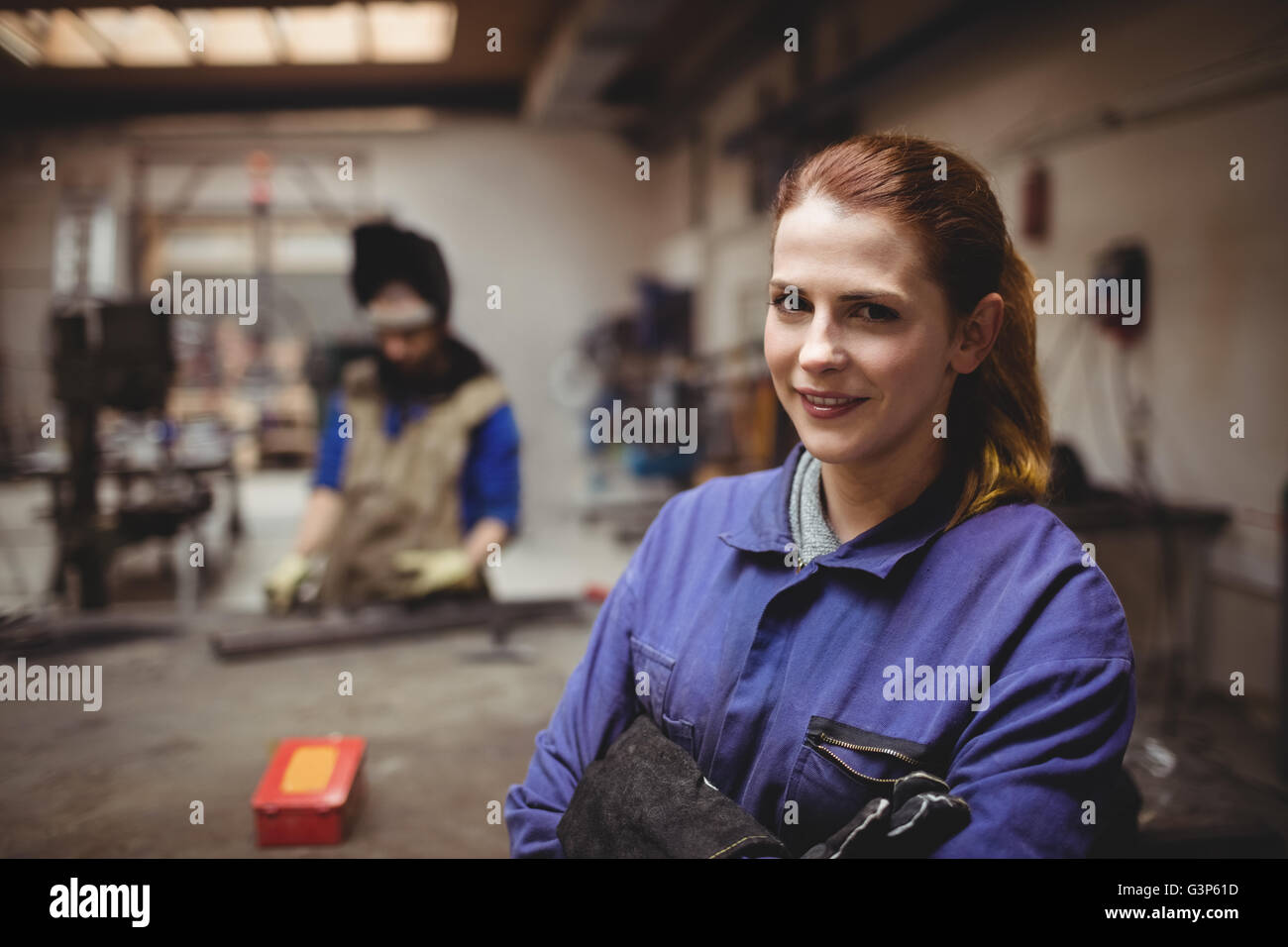 Female welder in protective workwear with colleagues Stock Photo