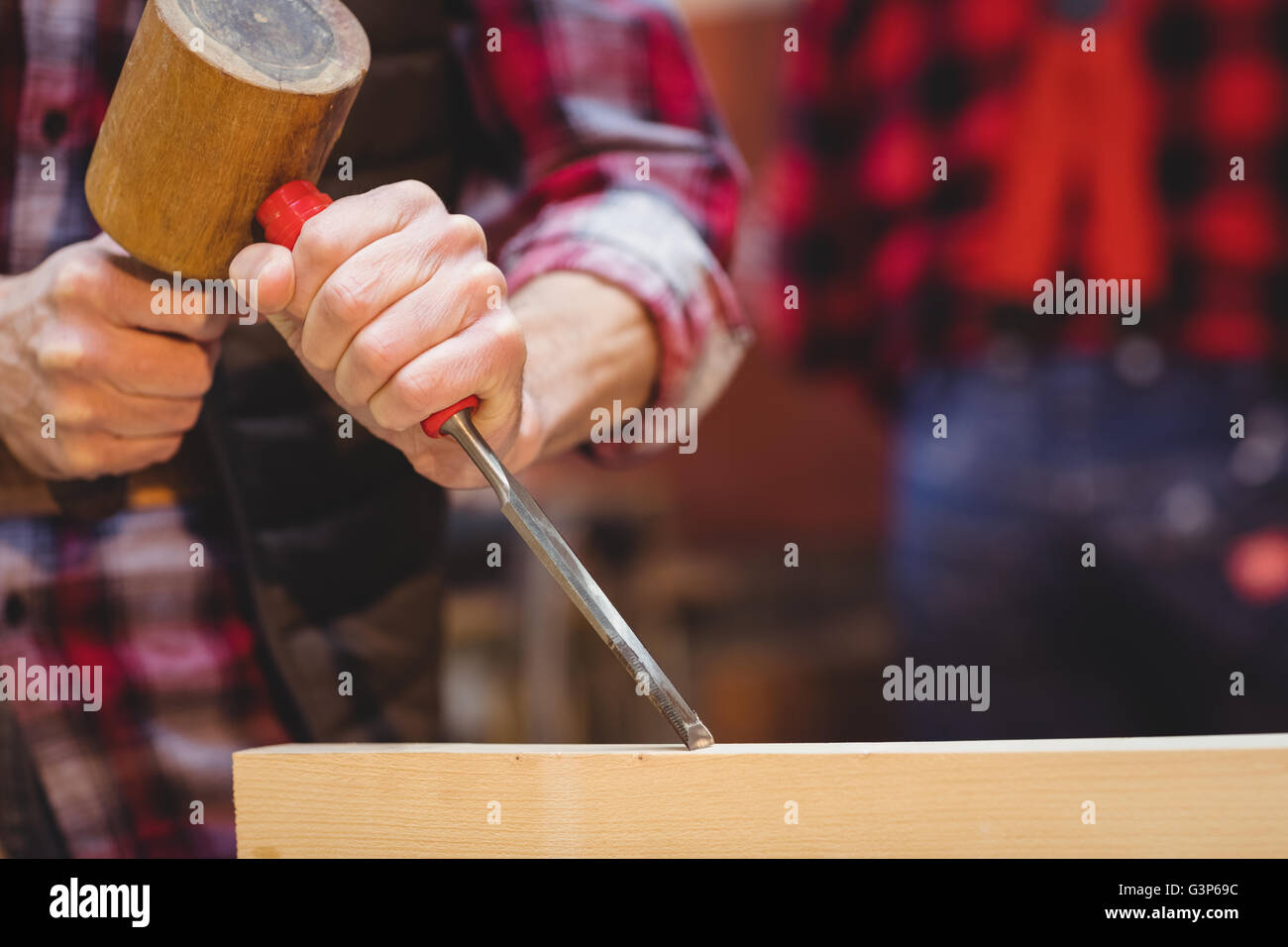 Close-up of carpenter perfecting wood plank form with a mallet Stock Photo