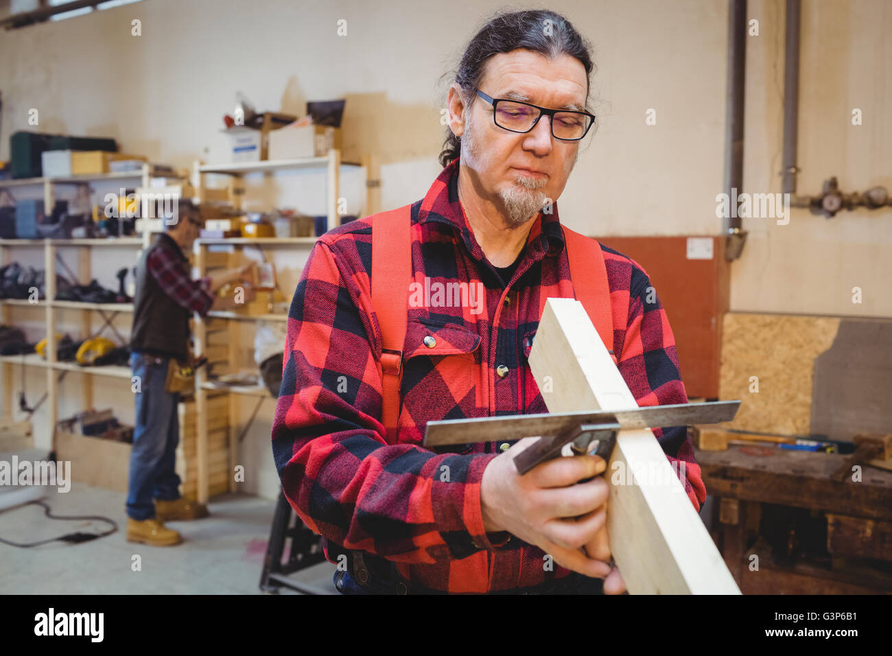 Carpenter looking if the wood plank is straight Stock Photo