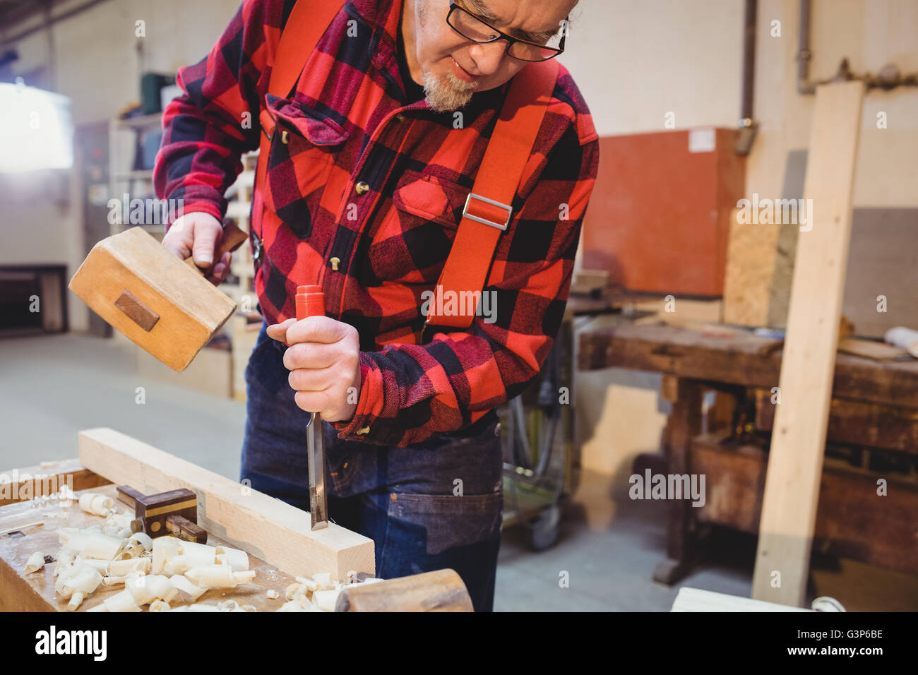 Focused carpenter working on wood plank Stock Photo