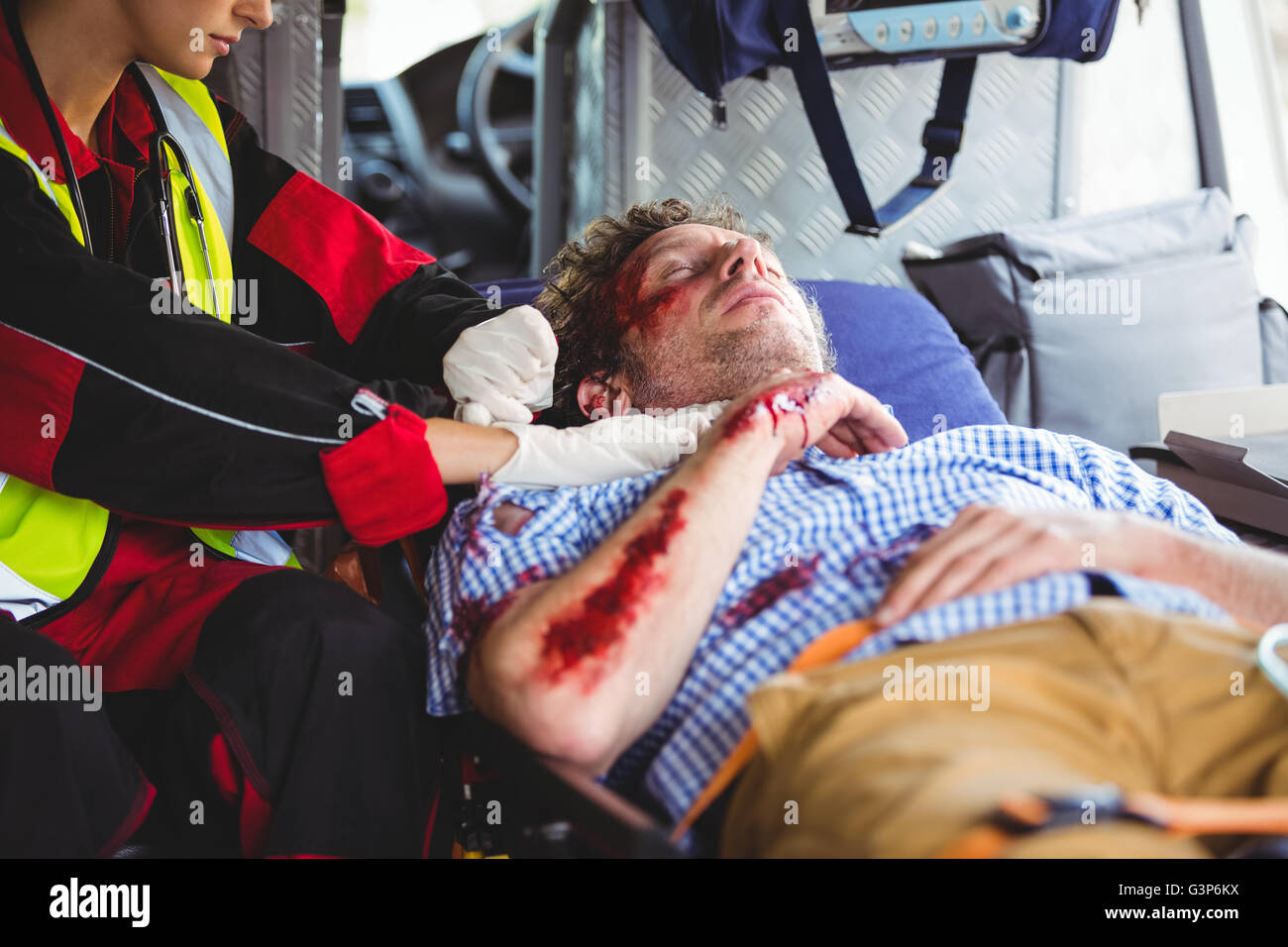 Injured man being taken care of ambulance crew Stock Photo