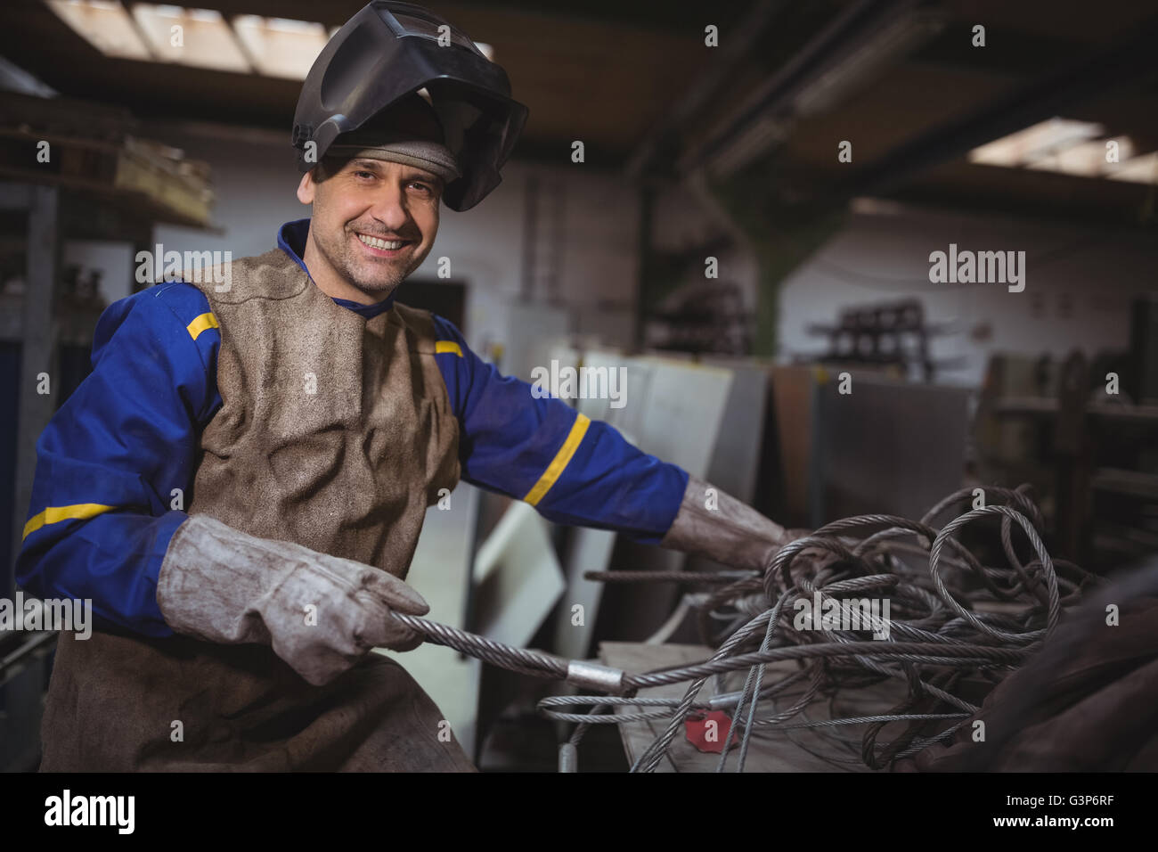 Portrait of smiling man working on a metal work Stock Photo