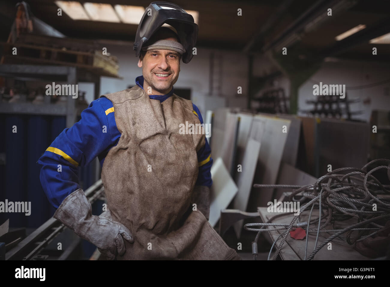 Portrait of smiling worker standing with hand on hip Stock Photo