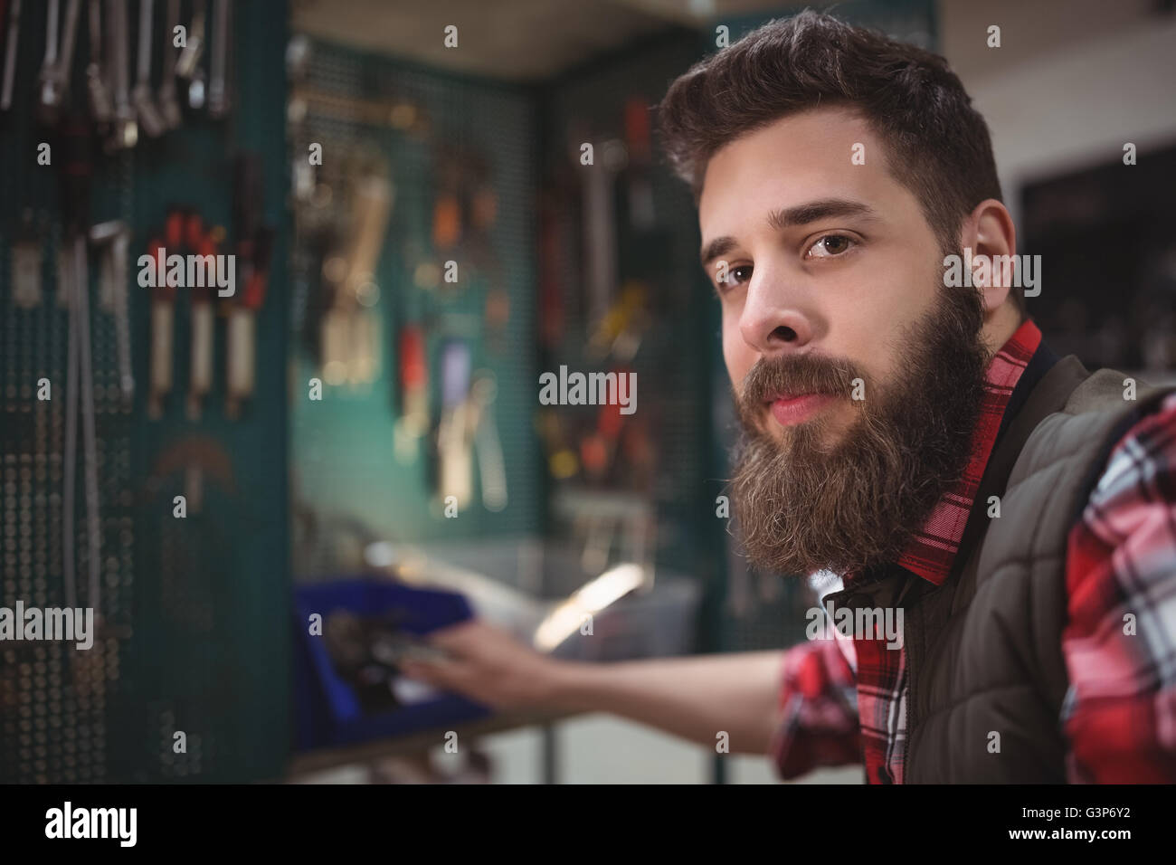 Portrait of mechanic searching a tool Stock Photo
