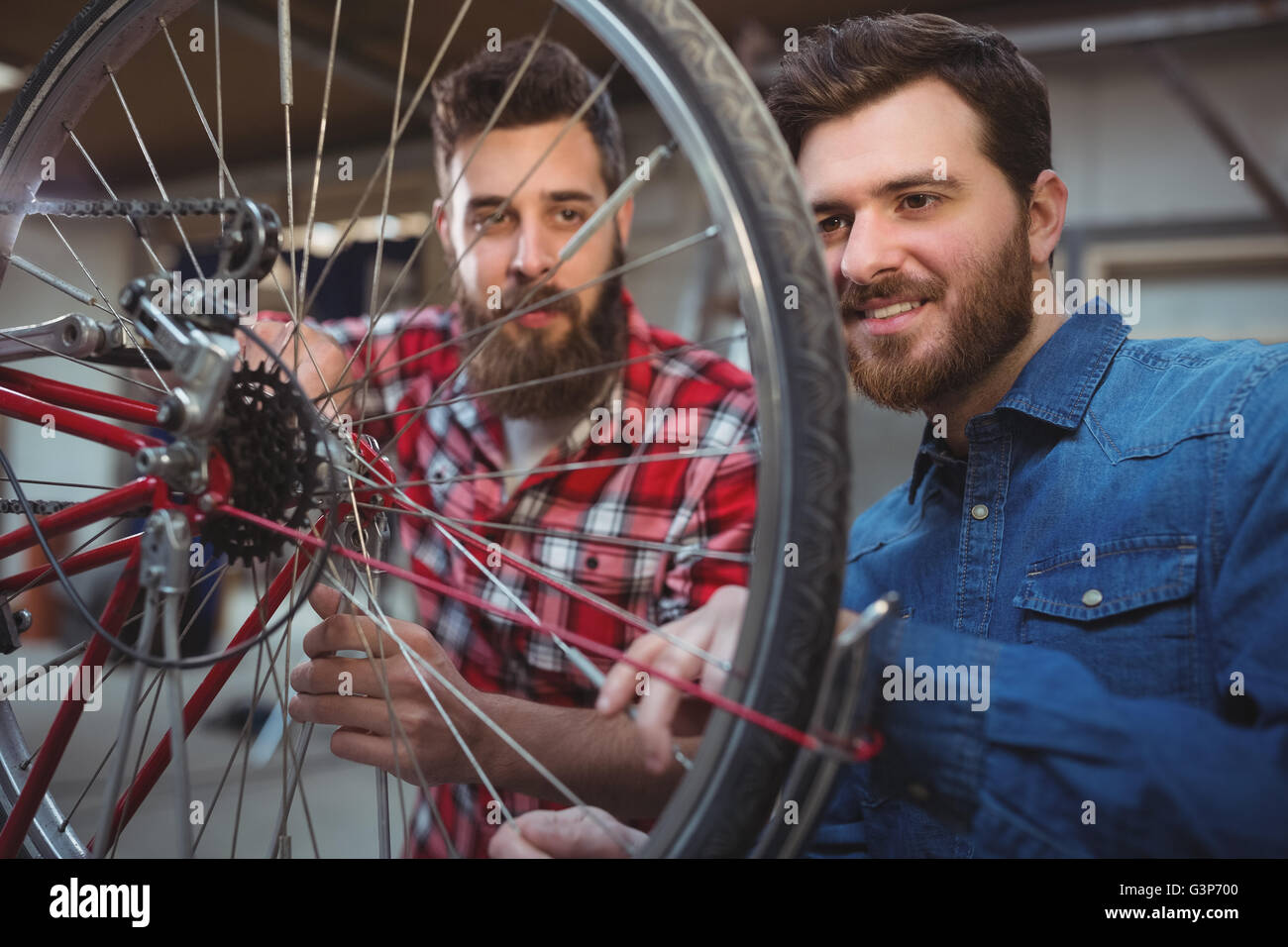 Two mechanics repairing a bicycle wheel Stock Photo Alamy
