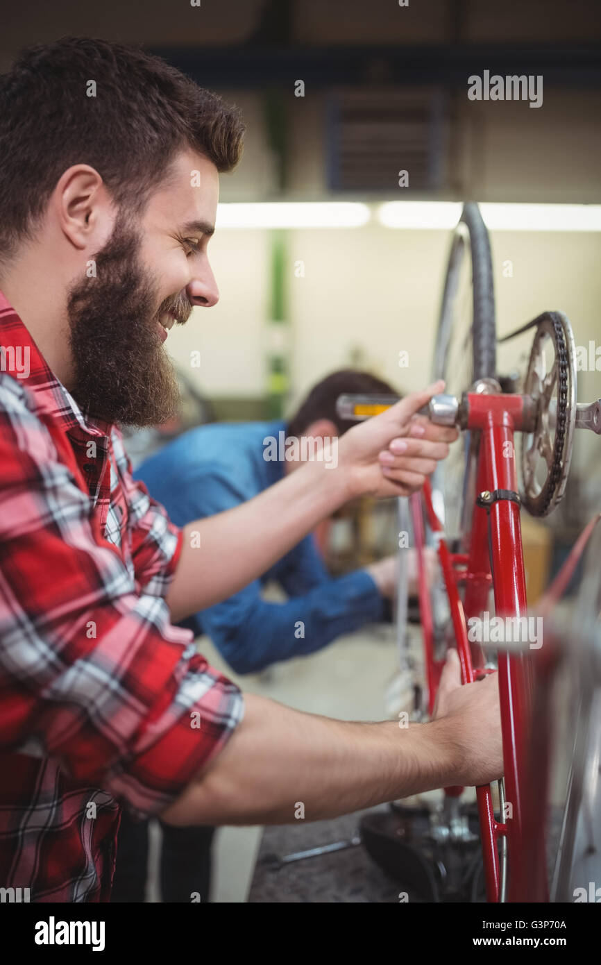 Profile view of mechanic repairing a bicycle Stock Photo