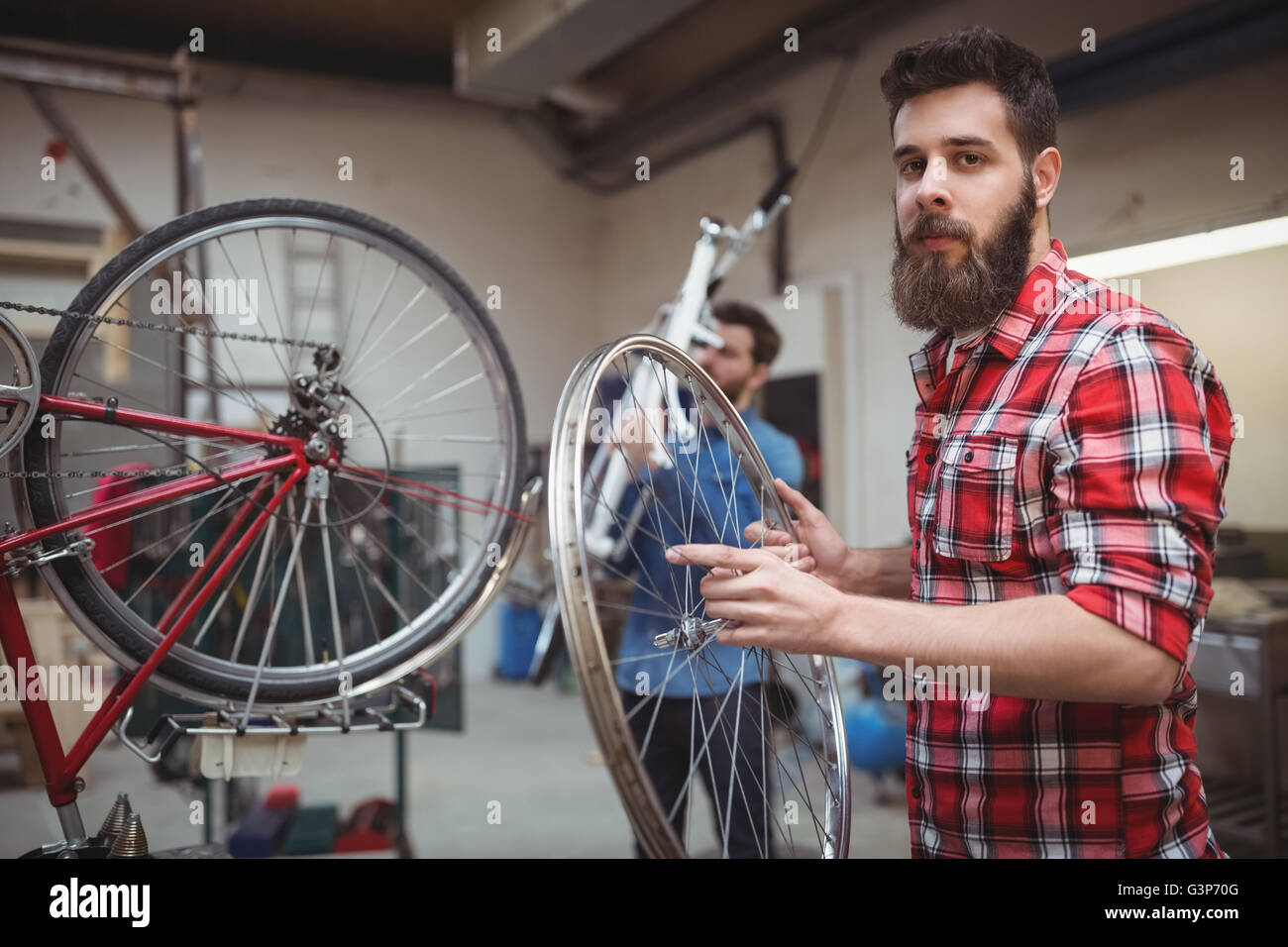 Mechanic holding a bicycle wheel Stock Photo