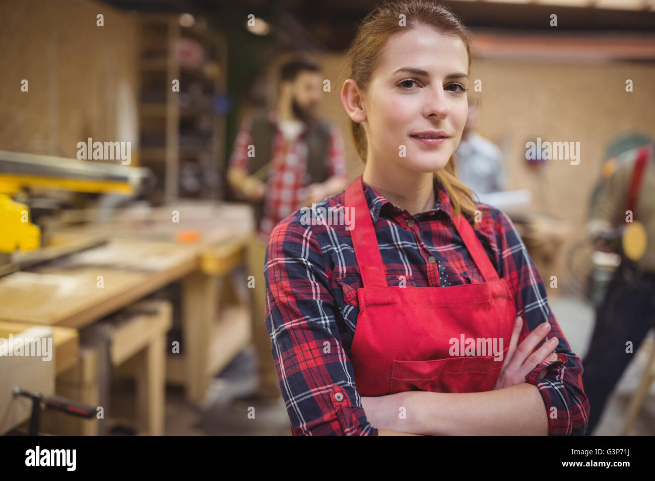 Portrait of female carpenter standing with arms crossed in workshop Stock Photo