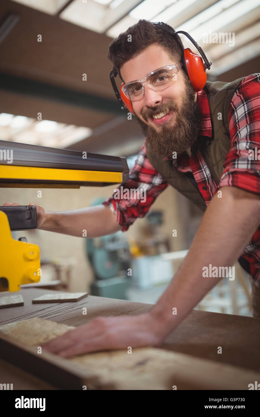 Carpenter cutting wooden plank with circular saw Stock Photo - Alamy