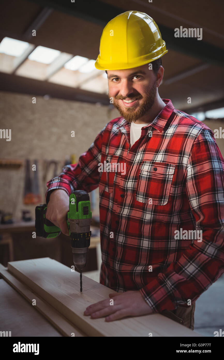 Young man using drill machine hires stock photography and images Alamy