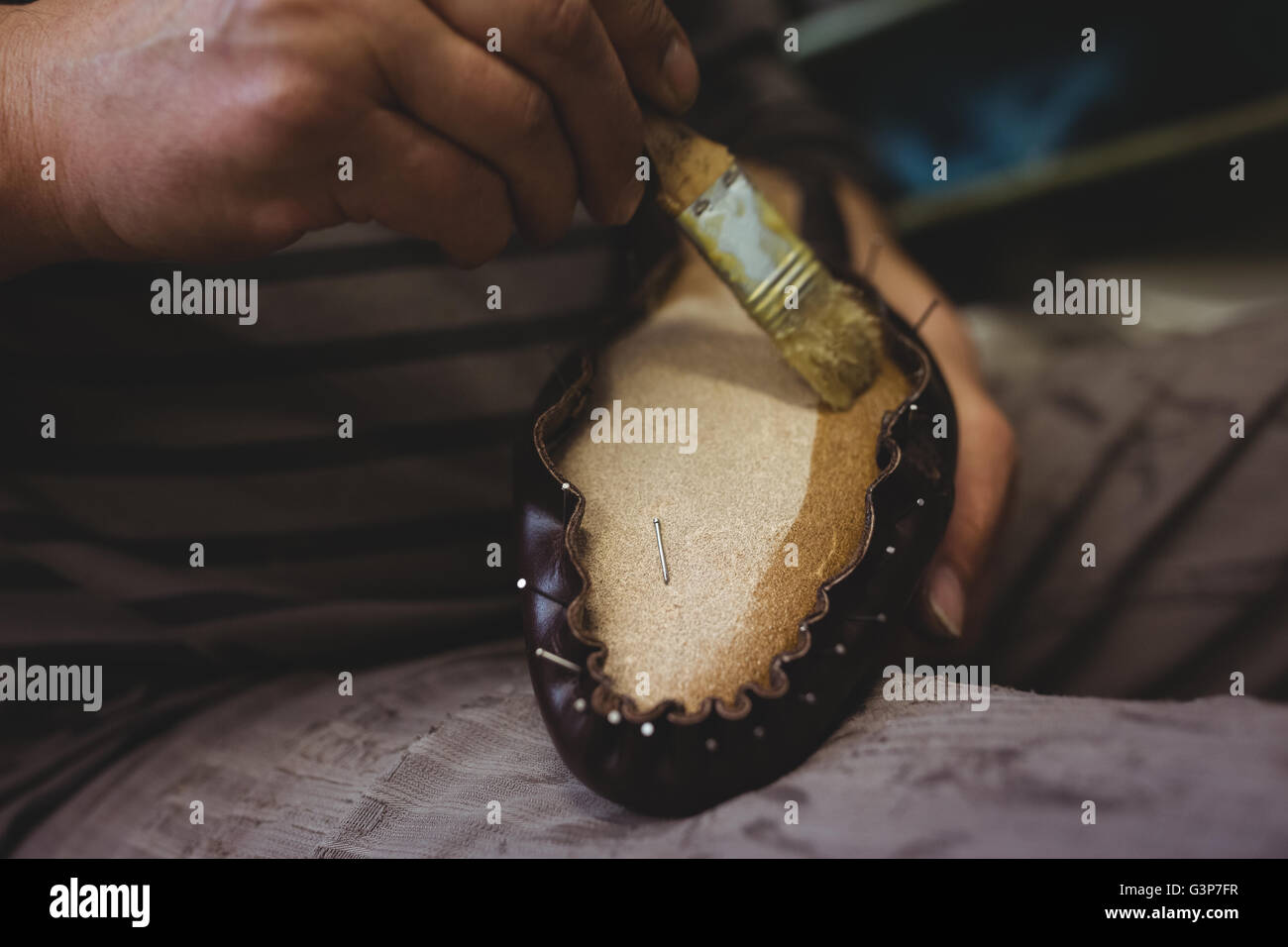 Cobbler applying glue on shoes Stock Photo Alamy