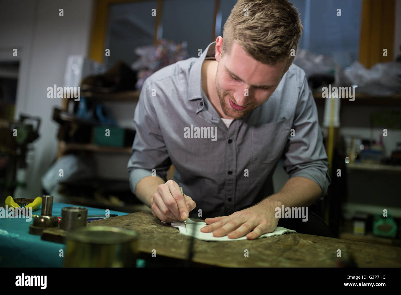 Cobbler cutting a piece of material Stock Photo Alamy