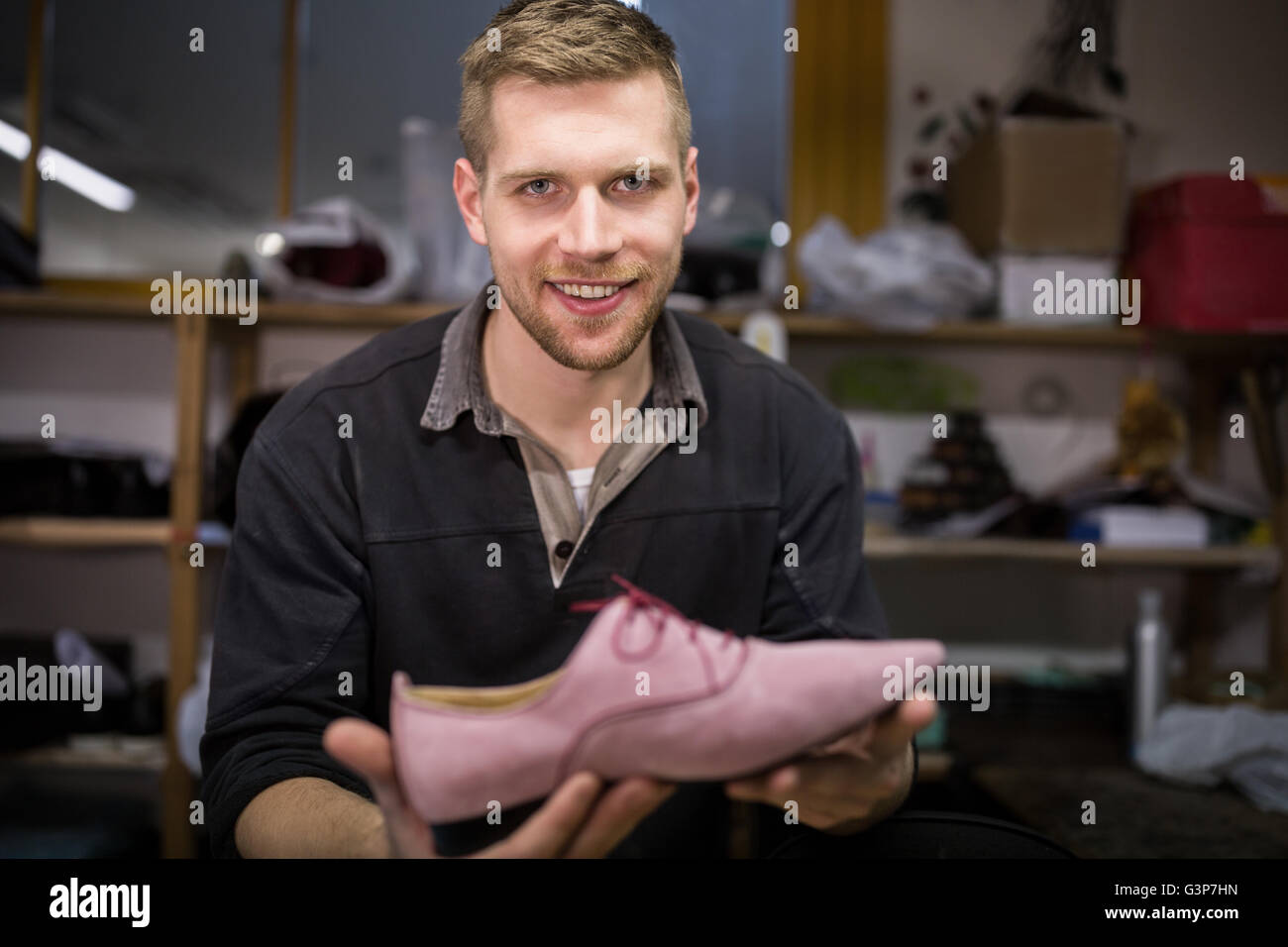 Portrait of cobbler holding a shoe Stock Photo
