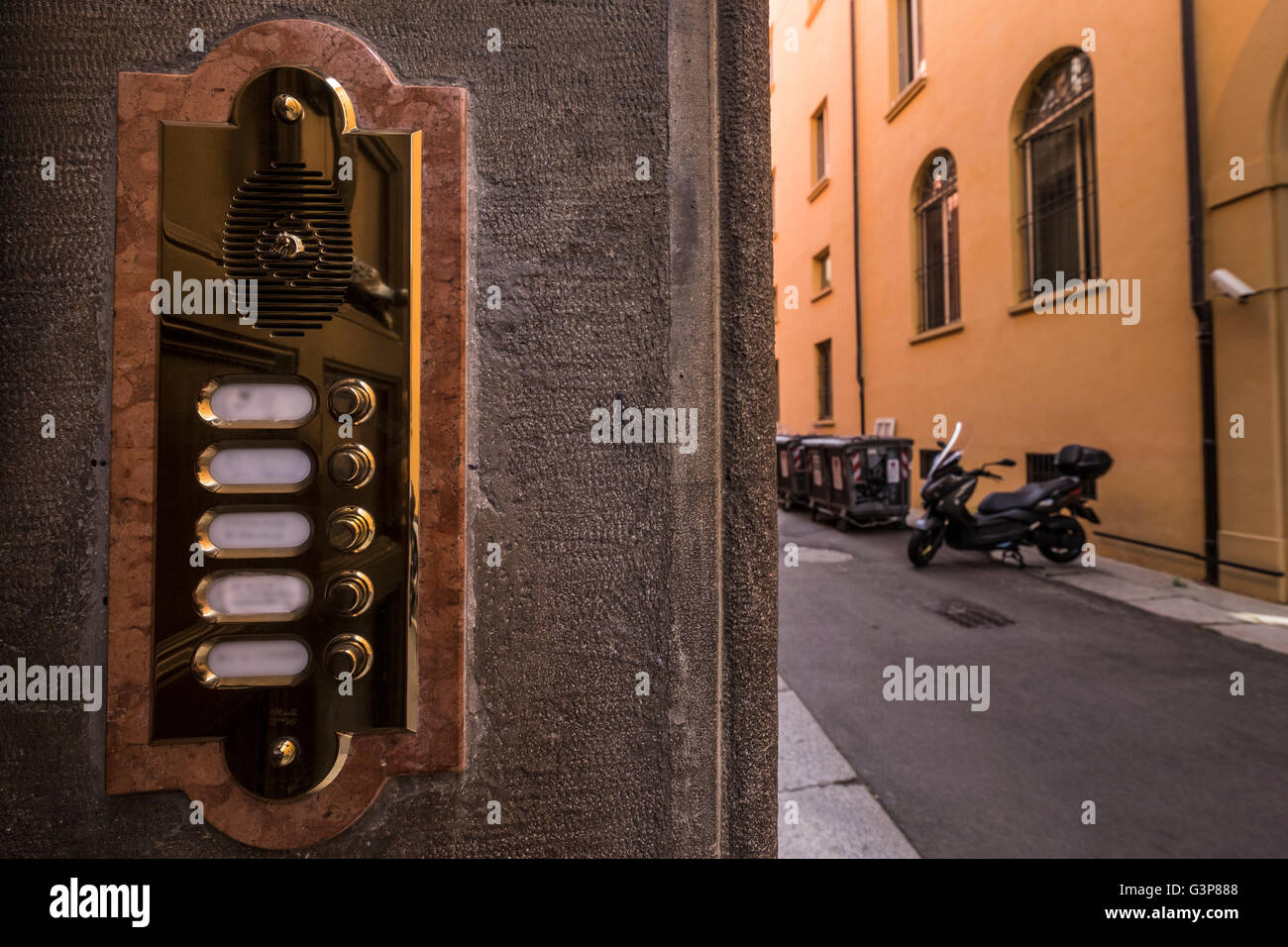 Highly polished shiny brass doorbell intercom at front door of apartment building in Bologna, Italy, with names blurred. Stock Photo