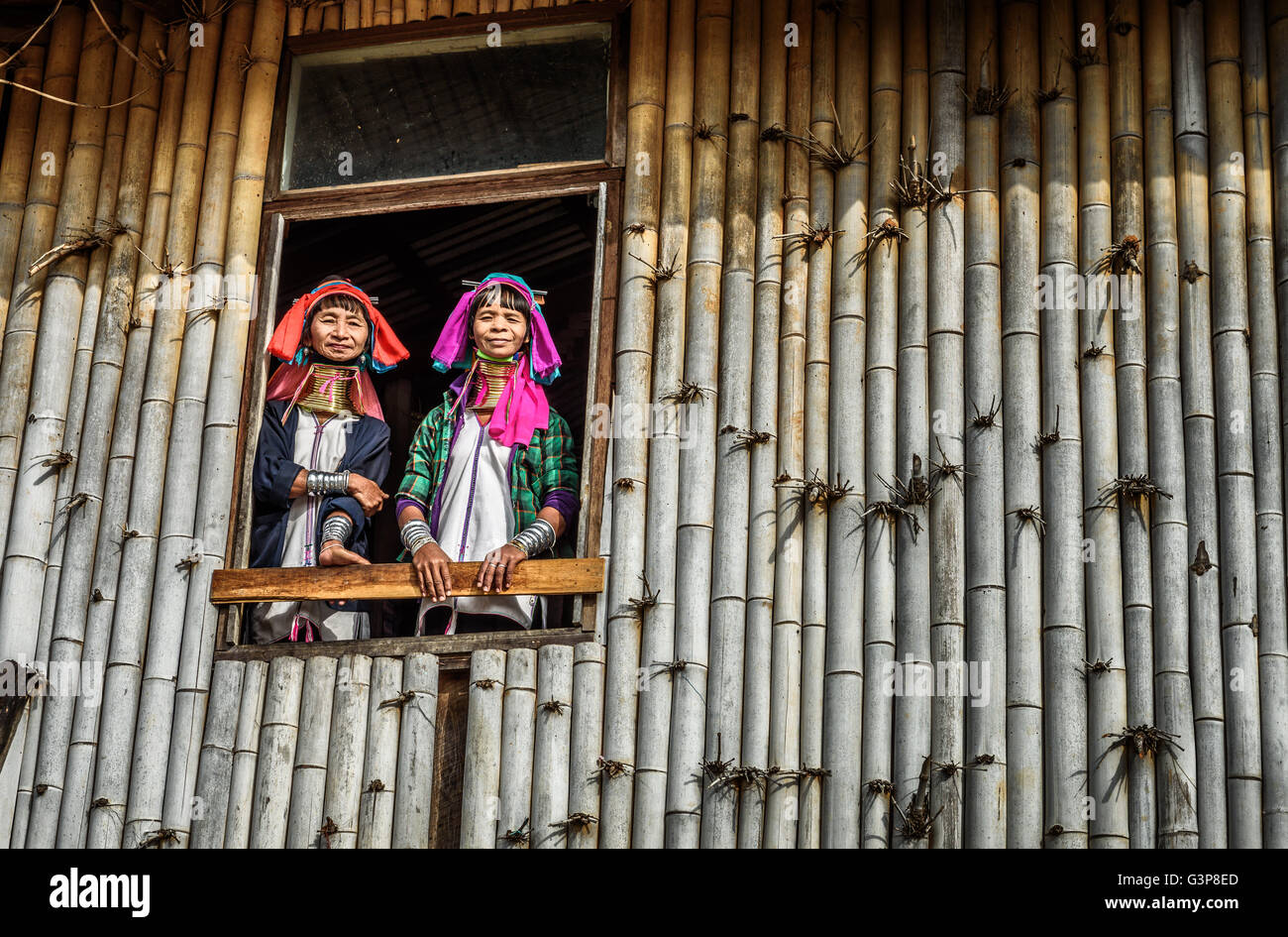 Women of the Kayan Lahwi tribe wearing traditional metal rings on their necks welcome visitors Stock Photo