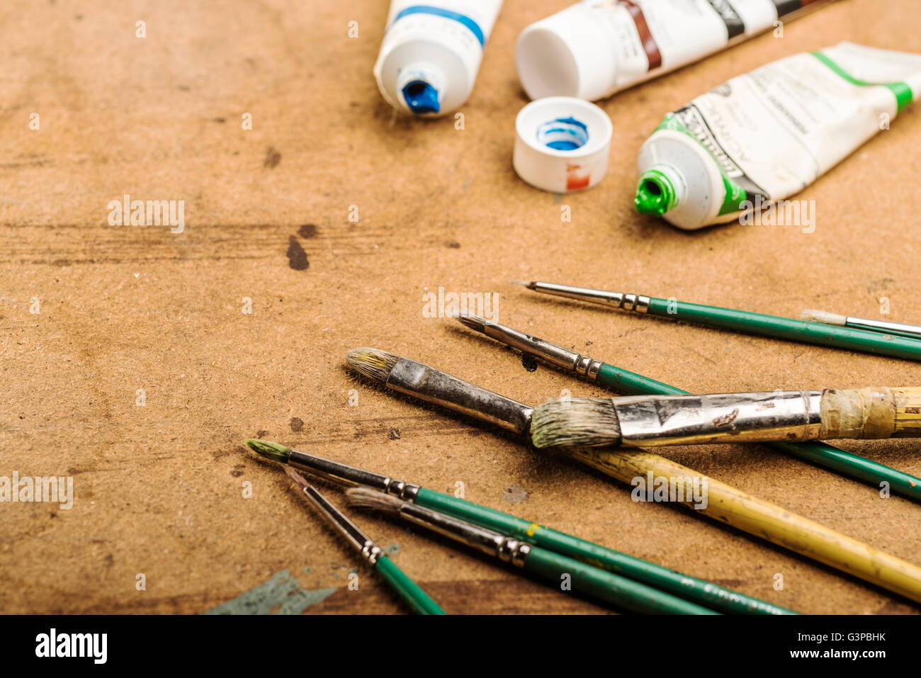 Brushes and paints laying on a studio table. Stock Photo