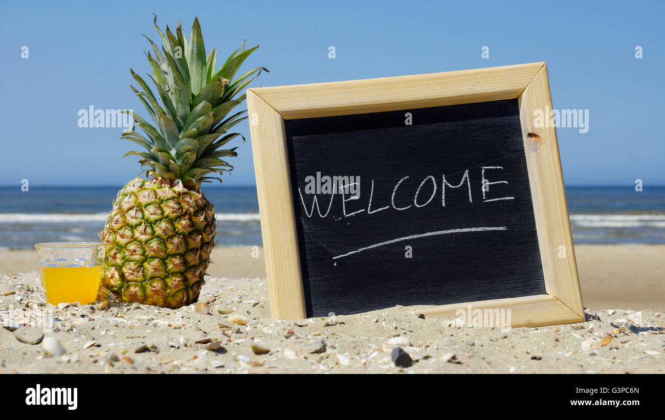 Welcome written on a chalkboard at the beach Stock Photo - Alamy