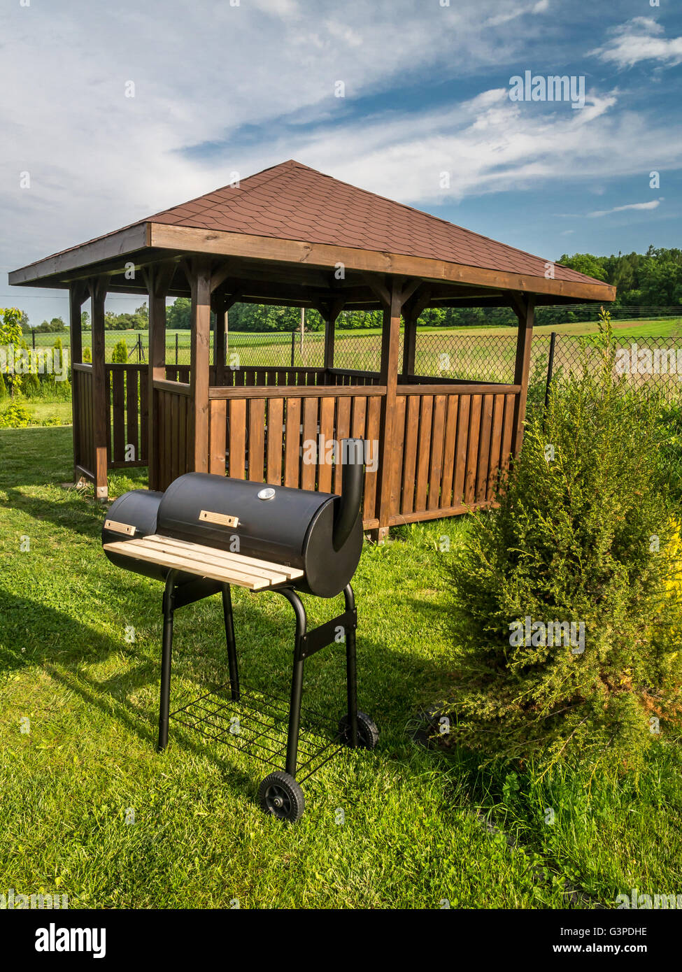 Wooden summer house with grill in the backyard Stock Photo