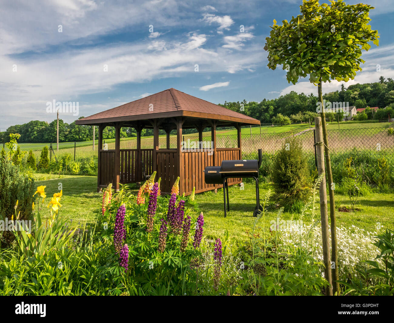 Wooden summer house with grill in the backyard Stock Photo