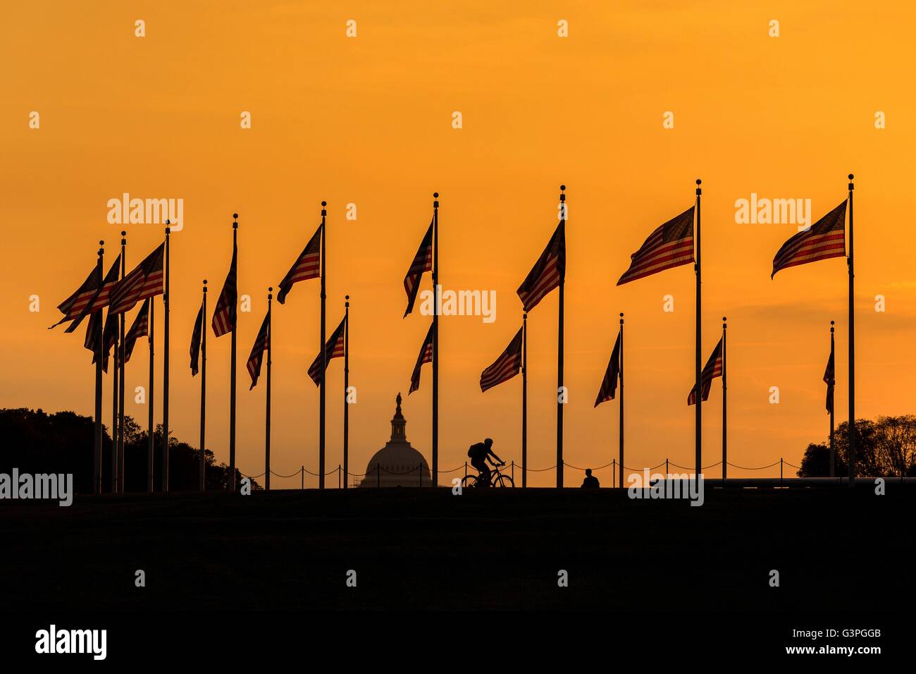 Flags fluttering around the Washington Monument silhouetted by sunset in Washington, DC. Stock Photo
