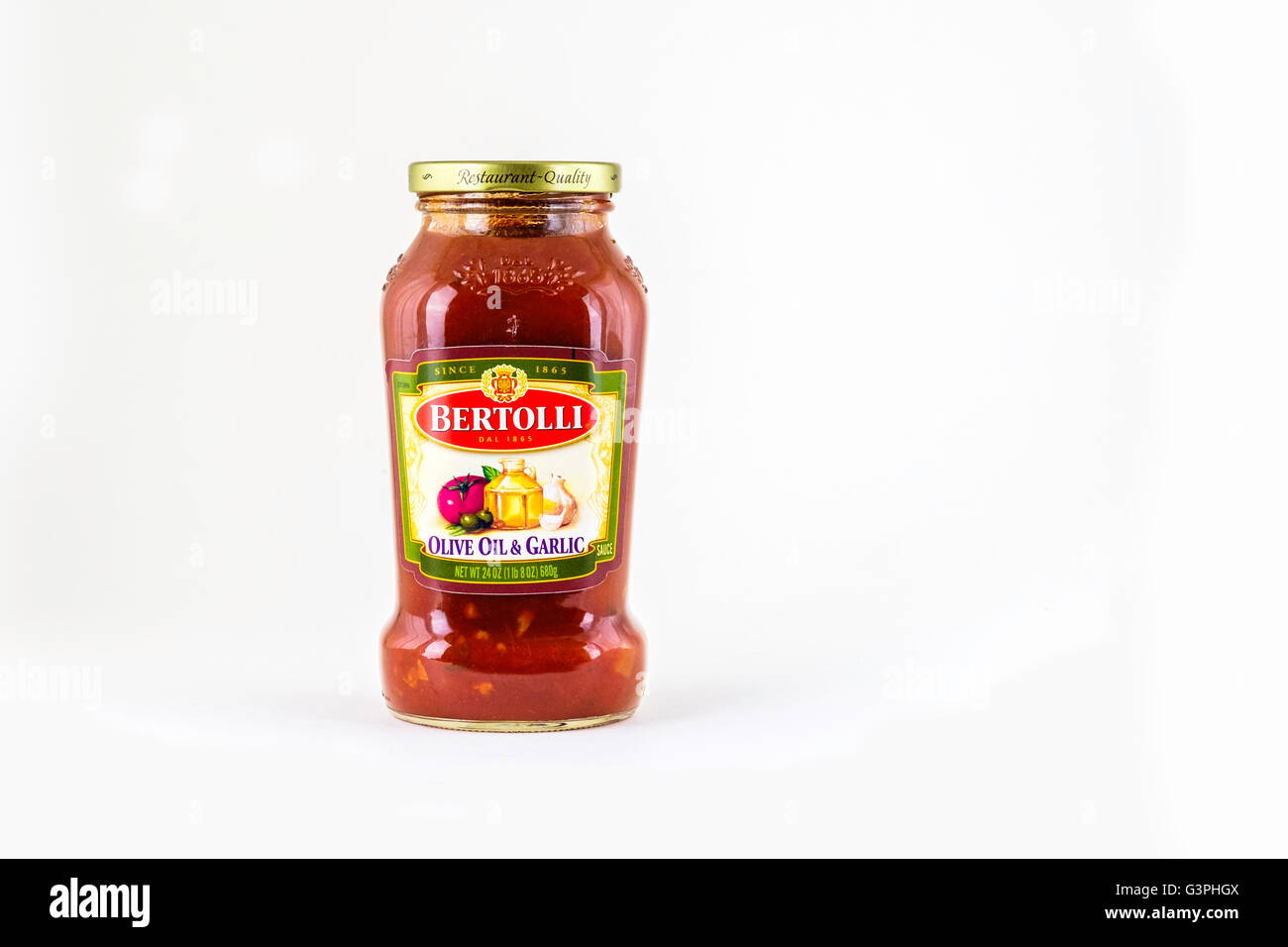 A glass jar of Bertolli brand olive oil & garlic flavored pasta sauce. USA. Stock Photo