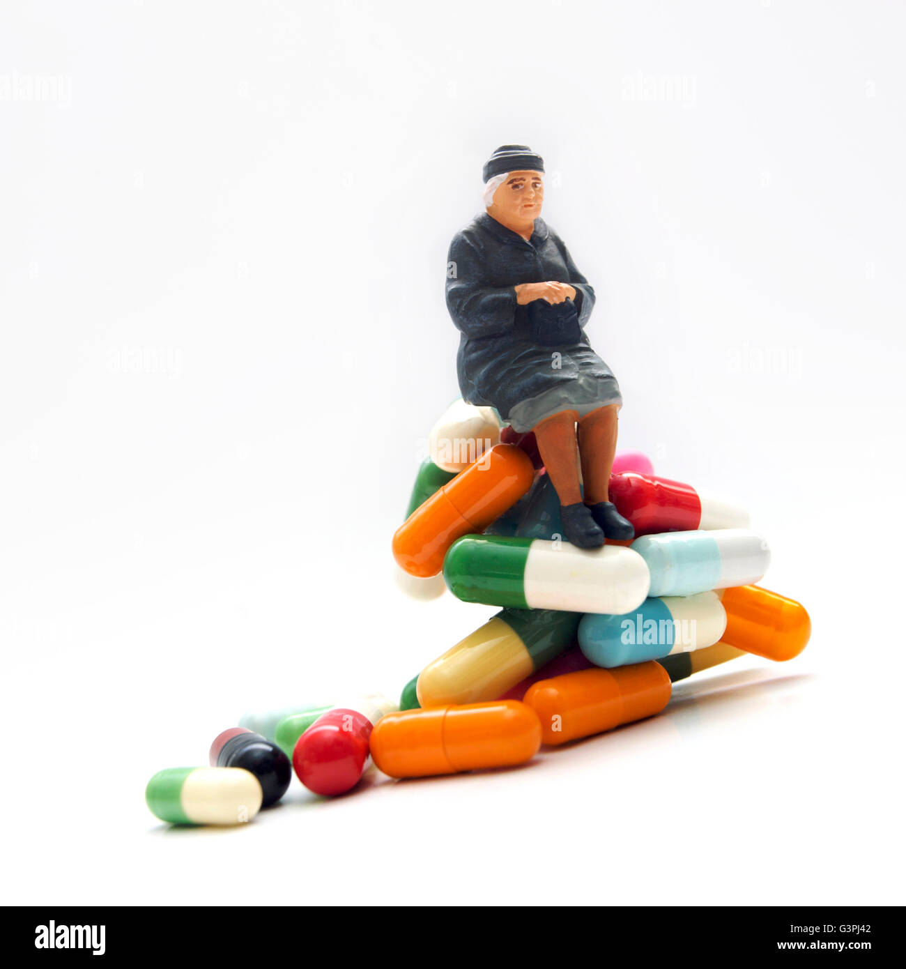 Woman, miniature figurine, sitting on pharmaceuticals Stock Photo