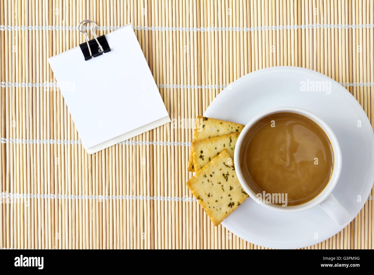 White cup of hot coffee and white sketch book on a mat Stock Photo