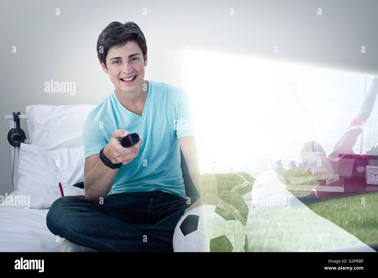 Composite image of young man is watching soccer match on television Stock Photo