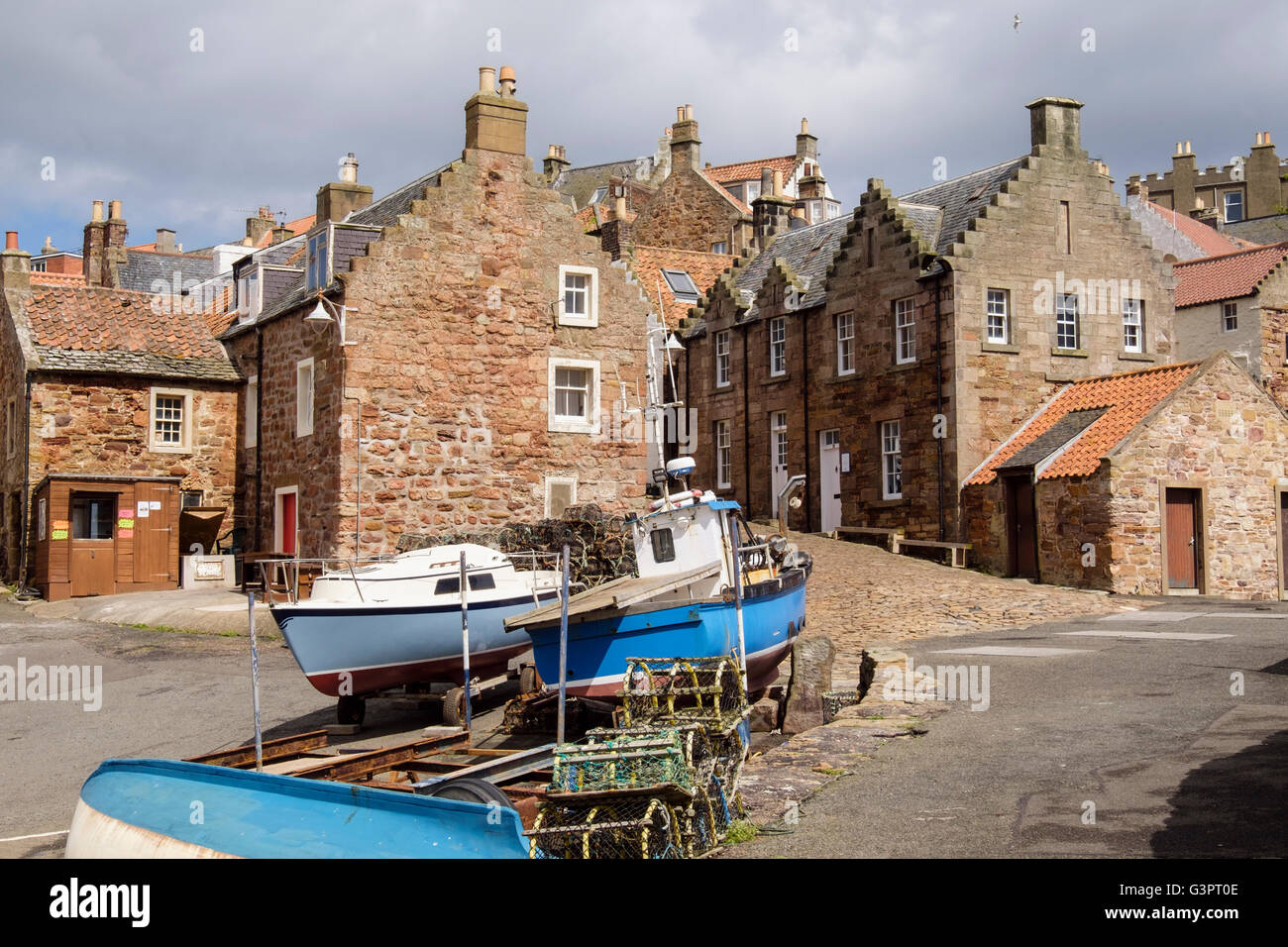 Fishing boats and old cottages by harbour in traditional old village on Firth of Forth coast. Crail East Neuk Fife Scotland UK Stock Photo