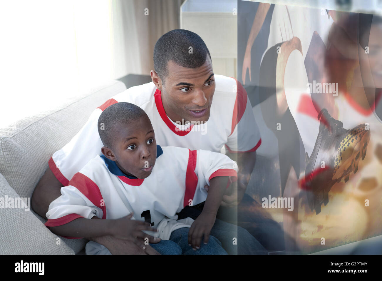 Composite image of father and son are watching sport on television Stock Photo
