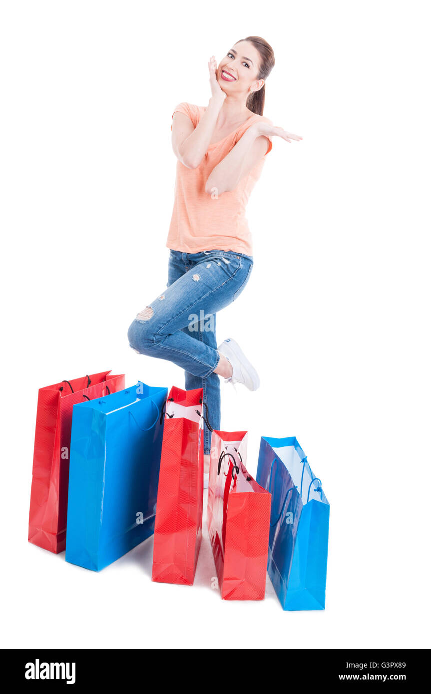 Young woman shopper standing and feeling joyful with many shopping bags isolated on white background Stock Photo