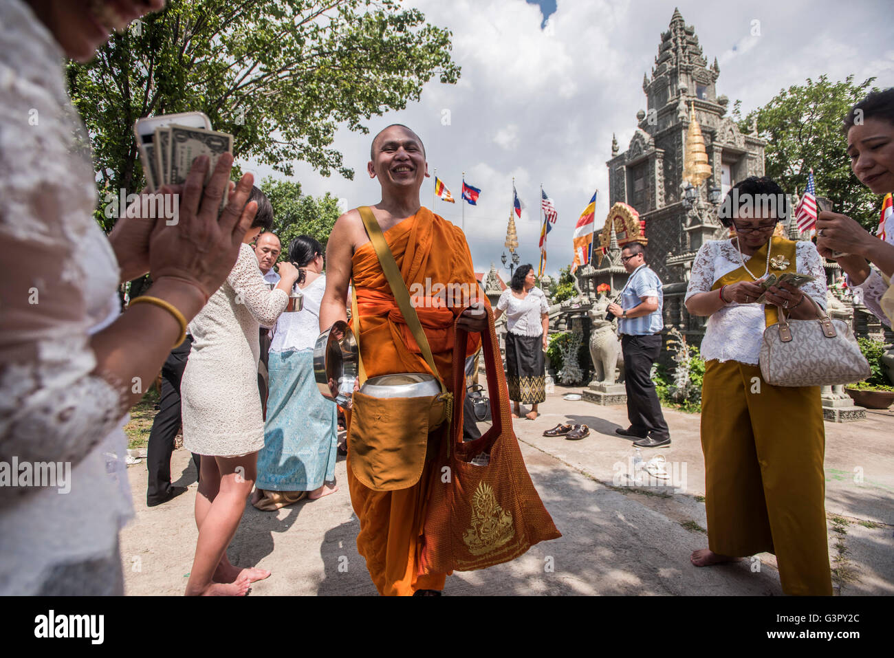 A Buddhist Monk receives food and money offerings during the Cambodian Festival, in Dallas, Tx. June 11, 2016. Stock Photo