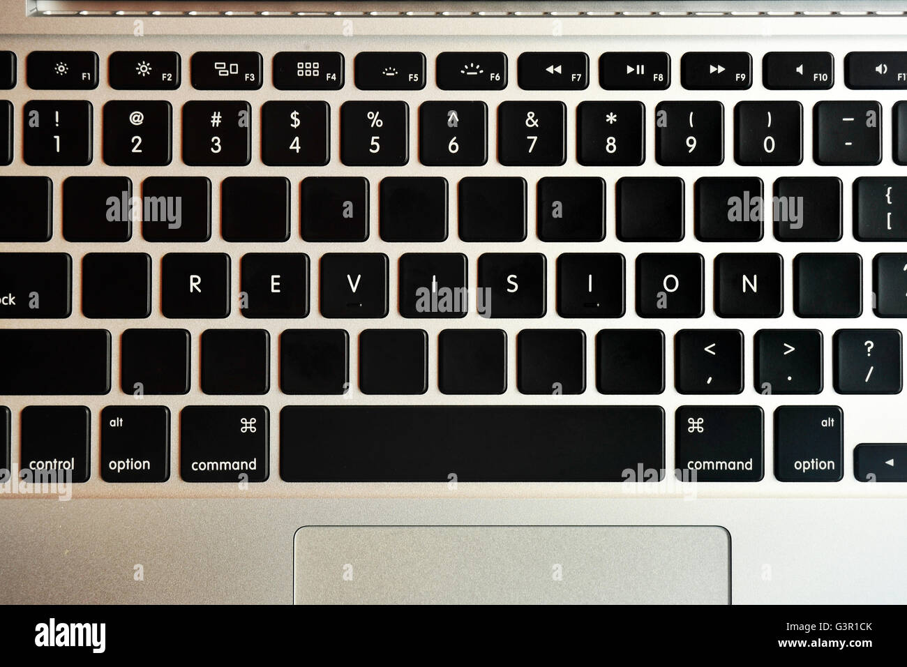 Revision written on the keyboard of a MacBook Pro. Stock Photo
