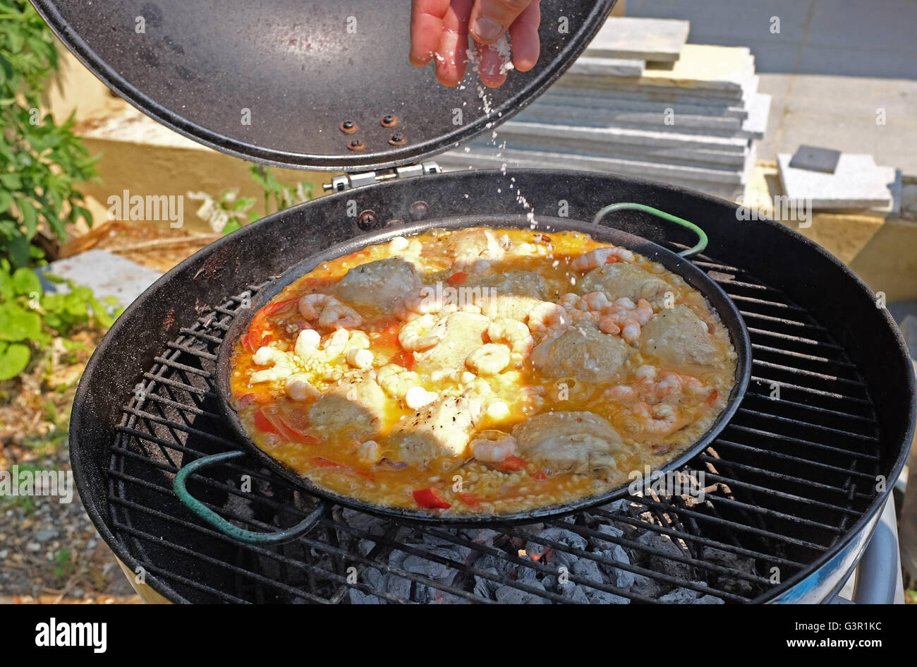 Prawn and chicken paella being cooked outside on a barbecue on hot